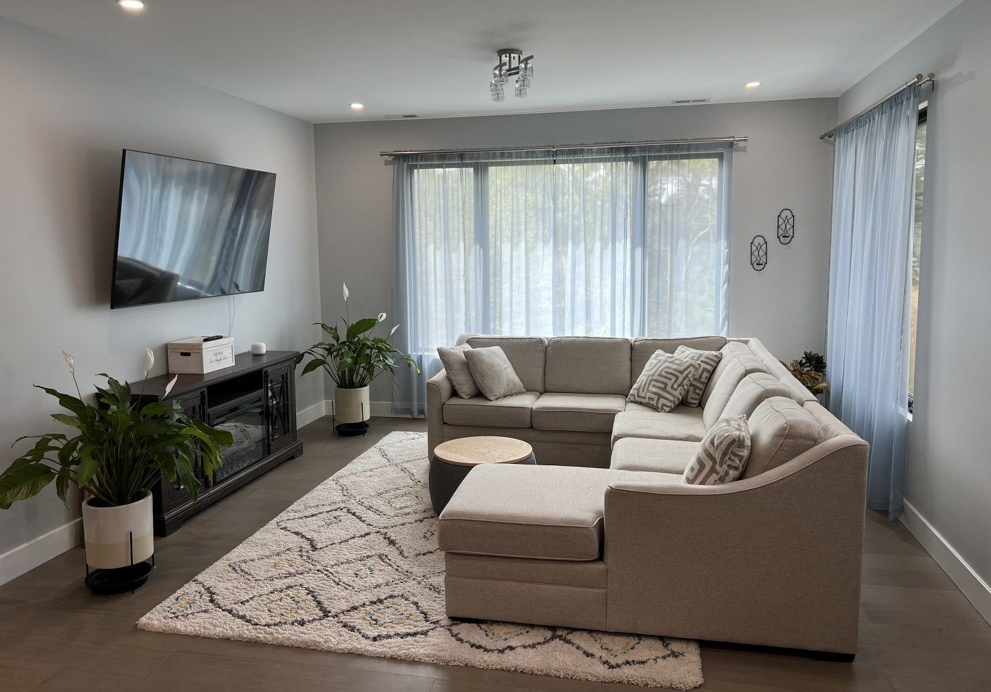 A living room with a large sectional couch and a flat screen tv.
