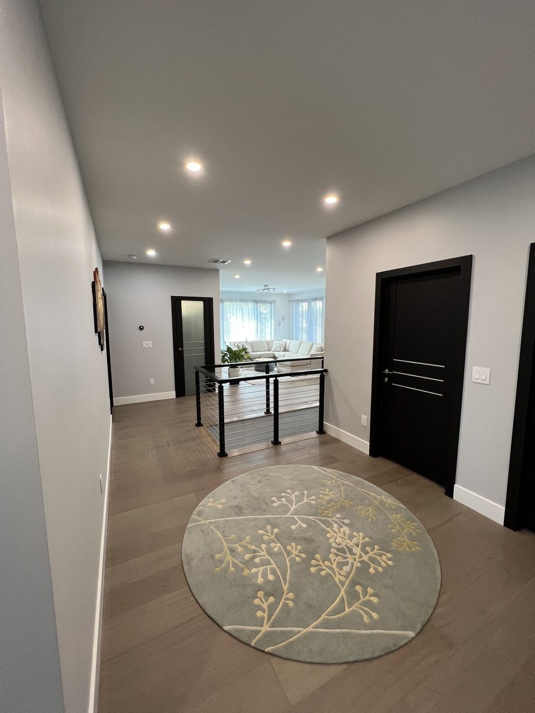 There is a round rug in the middle of the hallway.