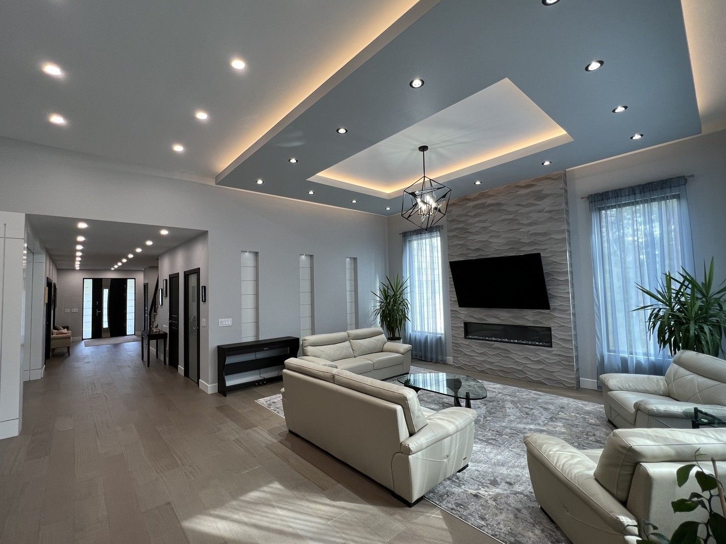 A living room with a couch , chairs , and a flat screen tv.