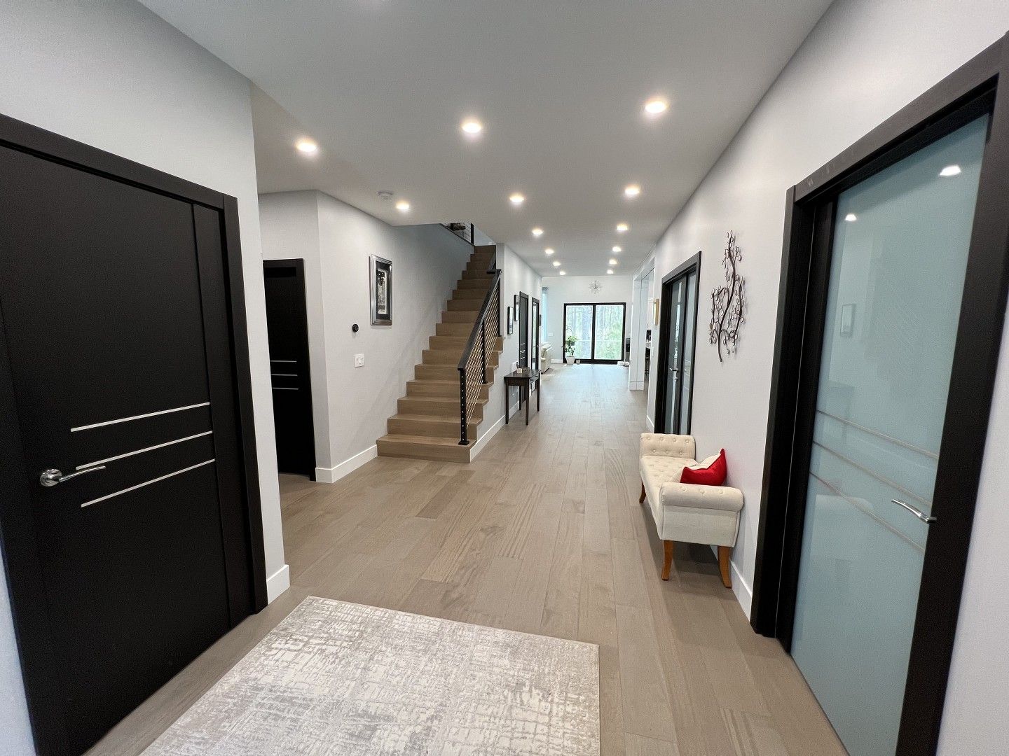A long hallway with stairs leading up to the second floor of a house.