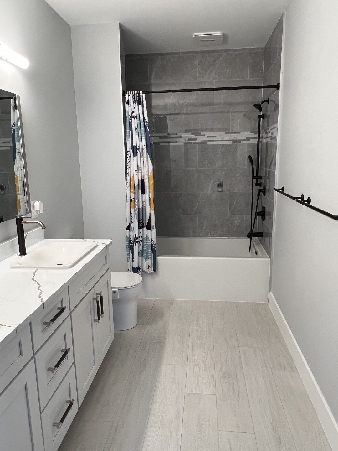 A bathroom with a toilet , sink , shower and bathtub.