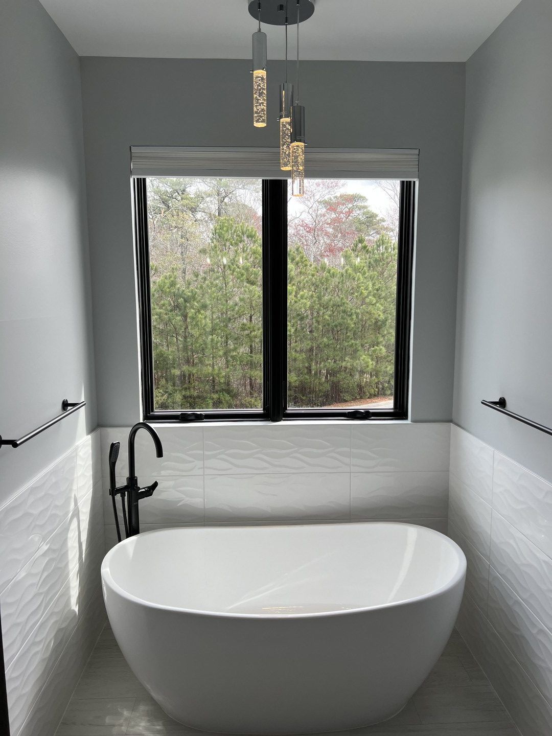 A bathroom with a bathtub and a window.