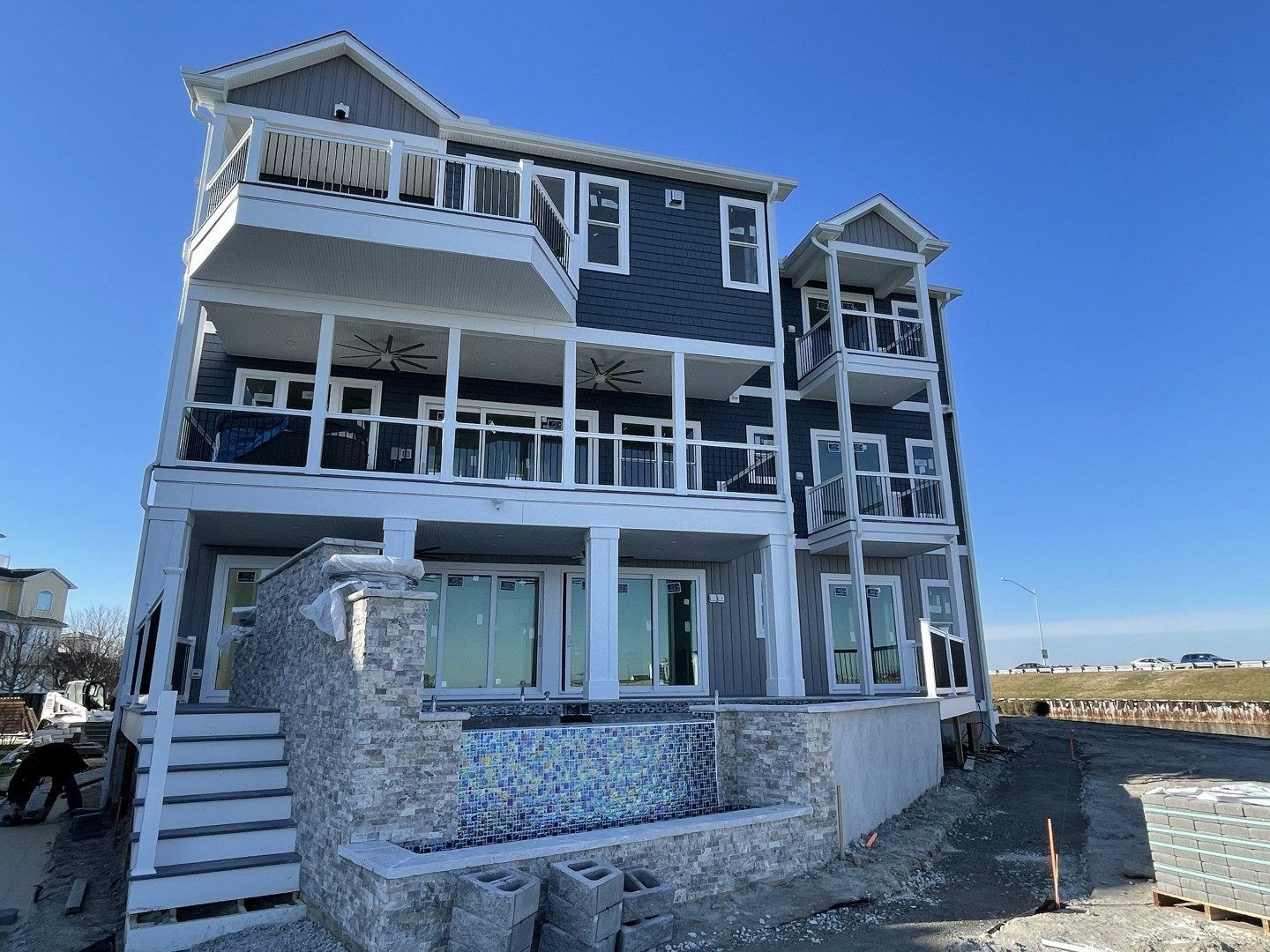 A large house with a lot of windows and balconies is being built on the beach.