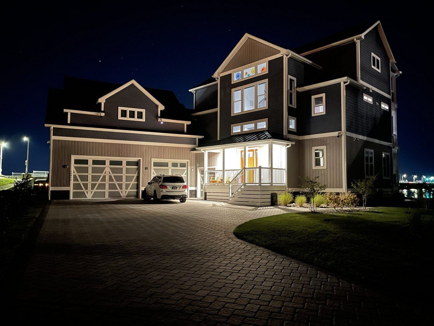 A large house with a car parked in front of it at night