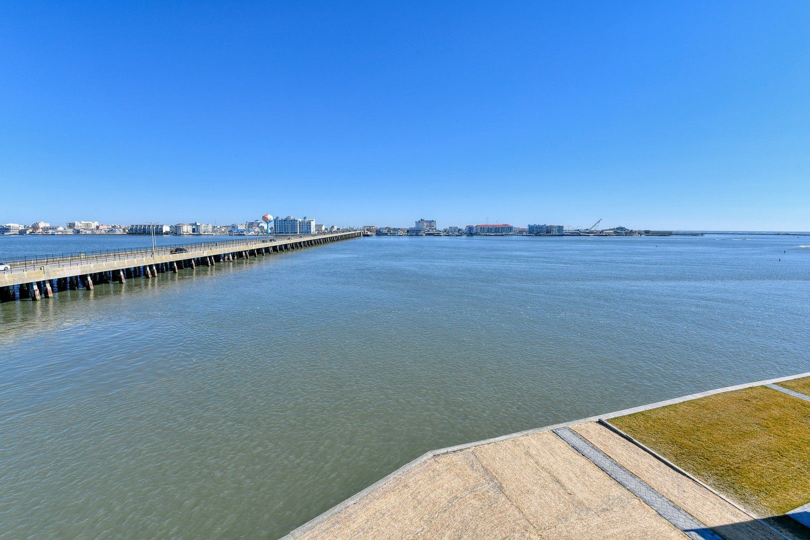 A bridge over a body of water with a city in the background.