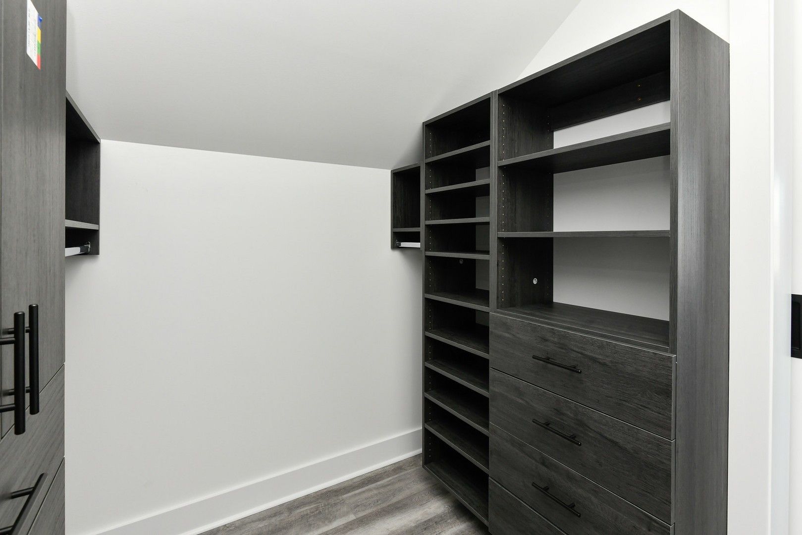 A walk in closet with lots of shelves and drawers.