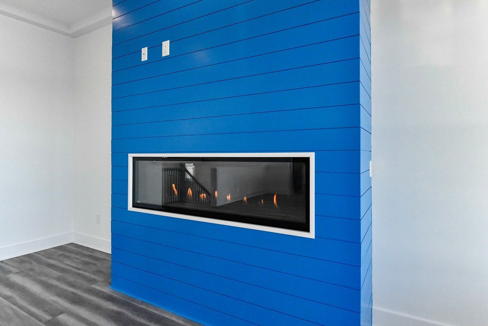 A fireplace is built into a blue wall in a living room.