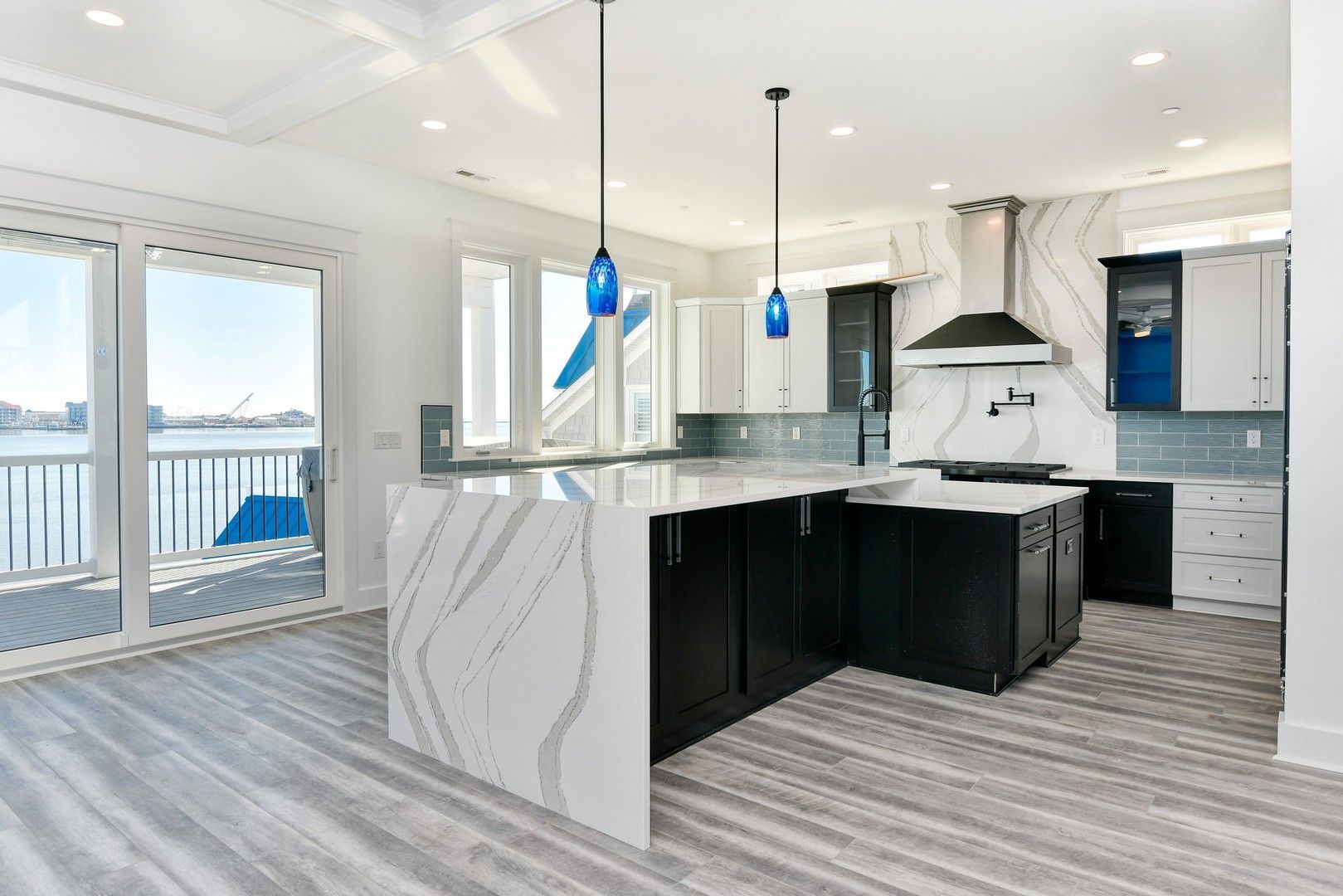 A kitchen with a large island and a view of the water.
