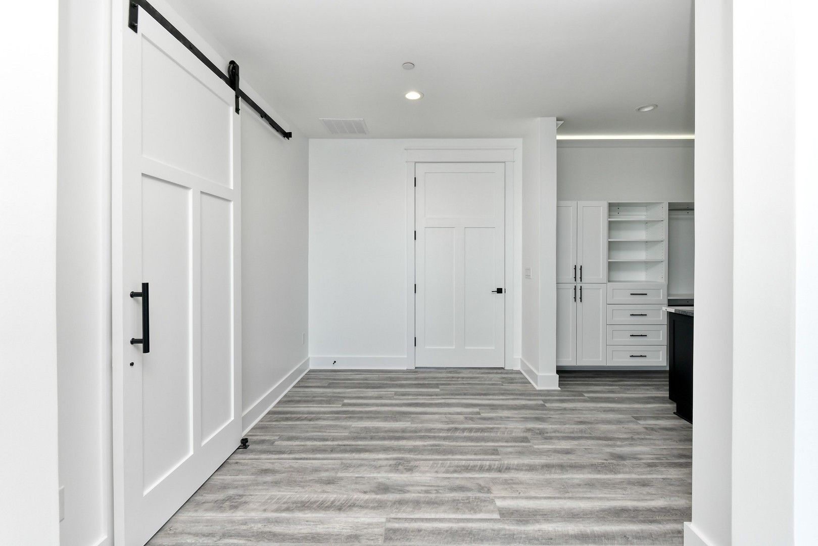 There is a sliding barn door in the hallway leading to the kitchen.