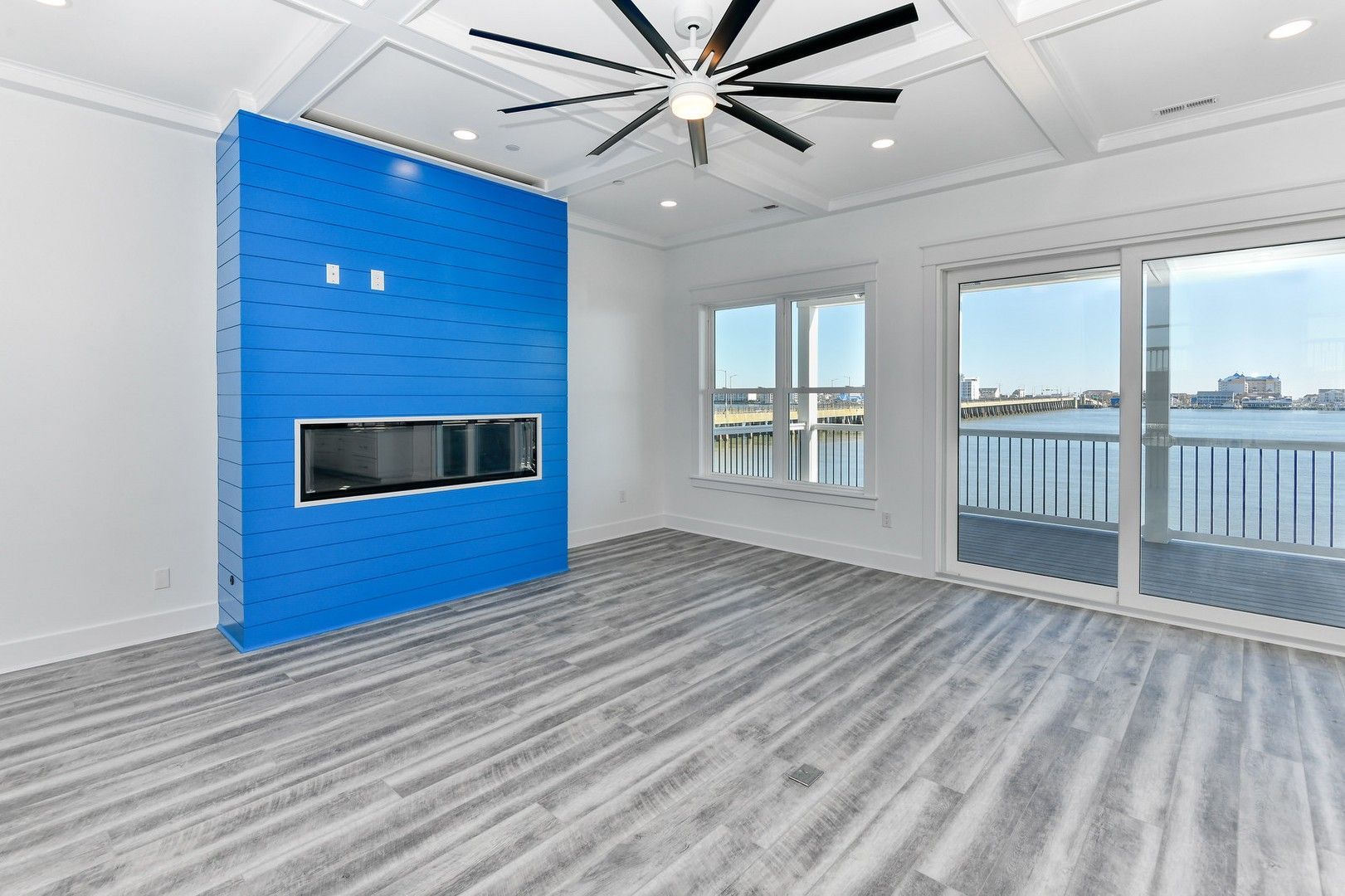 A living room with a blue fireplace and a ceiling fan.