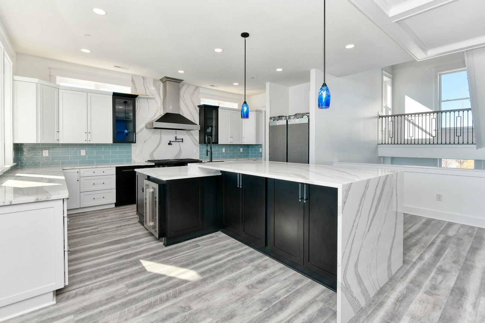 A kitchen with black and white cabinets and a large island.