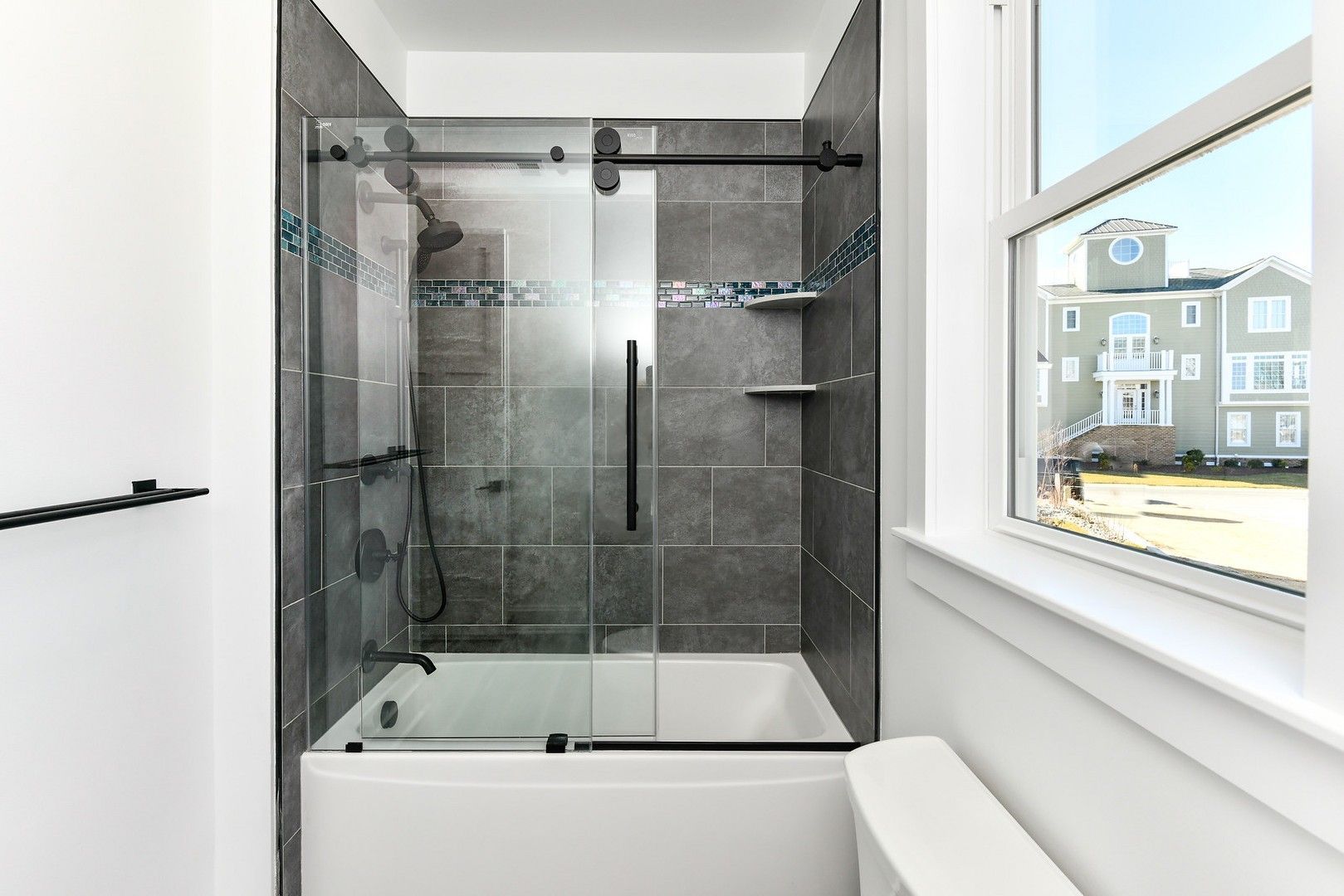 A bathroom with a tub and a shower with a sliding glass door.