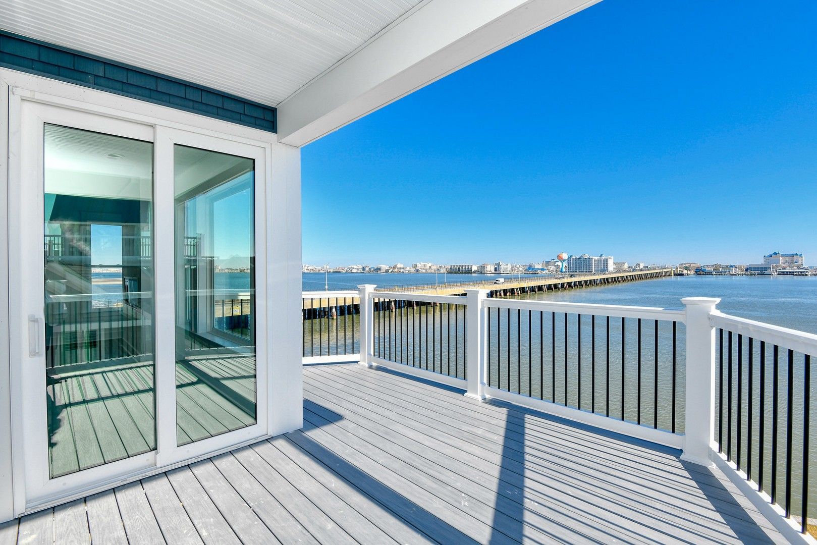 A balcony with a view of a body of water and a bridge.