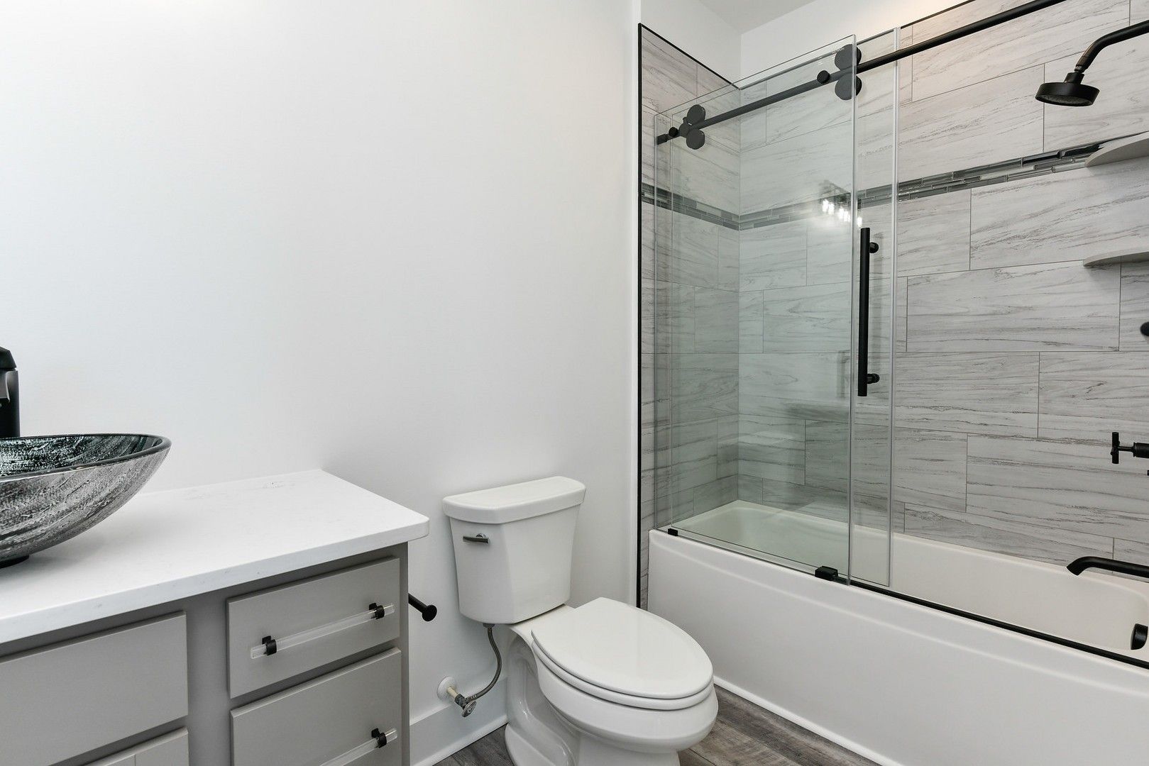 A bathroom with a toilet , sink , shower and bathtub.