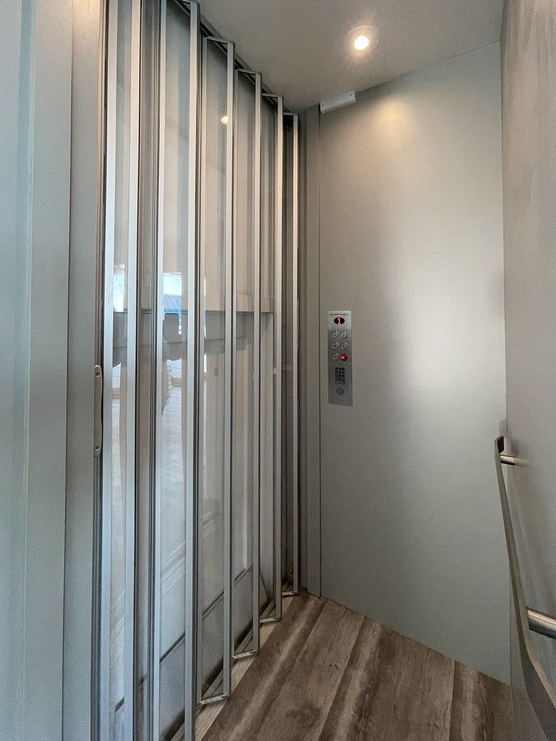 A bathroom with a sliding glass door and a wooden floor.
