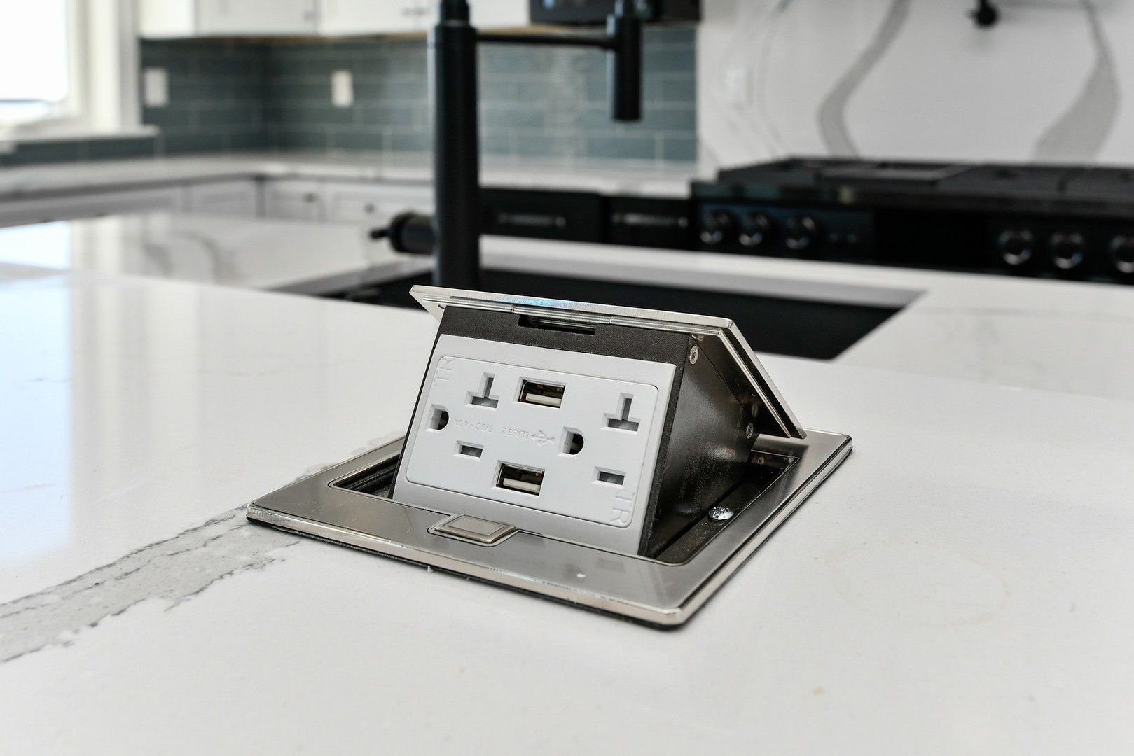 A kitchen counter with a power outlet and a usb port.