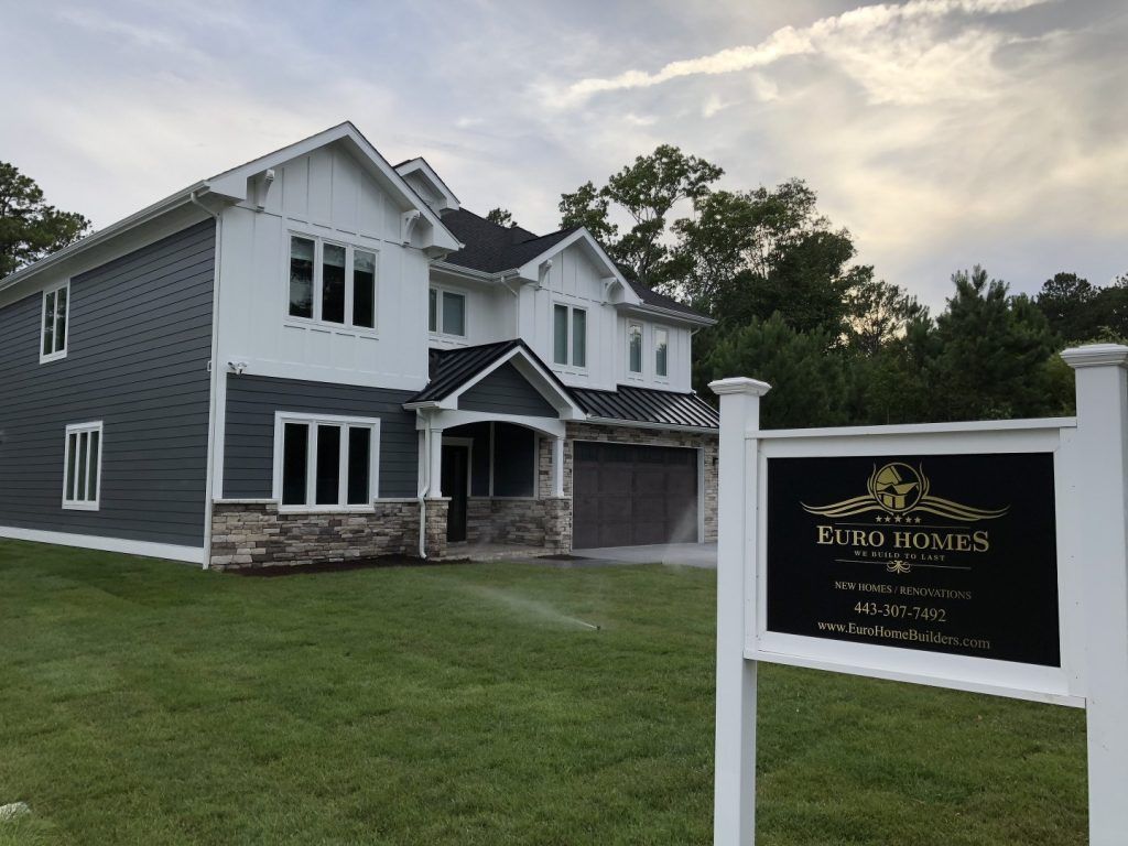 A large house with a for sale sign in front of it