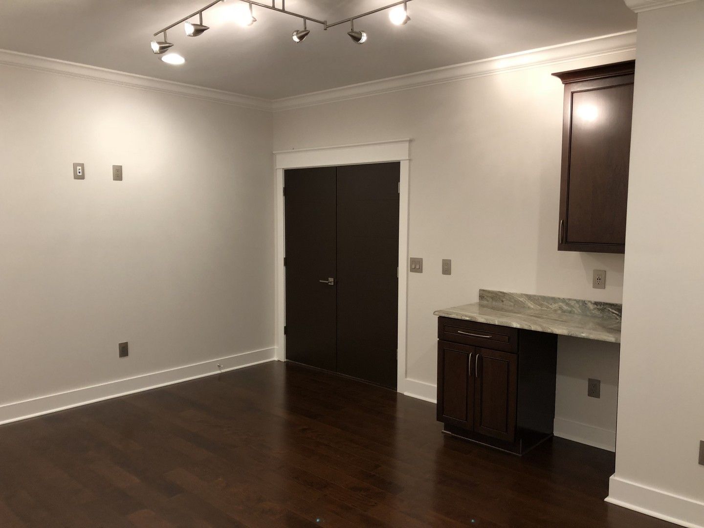 An empty room with hardwood floors and white walls