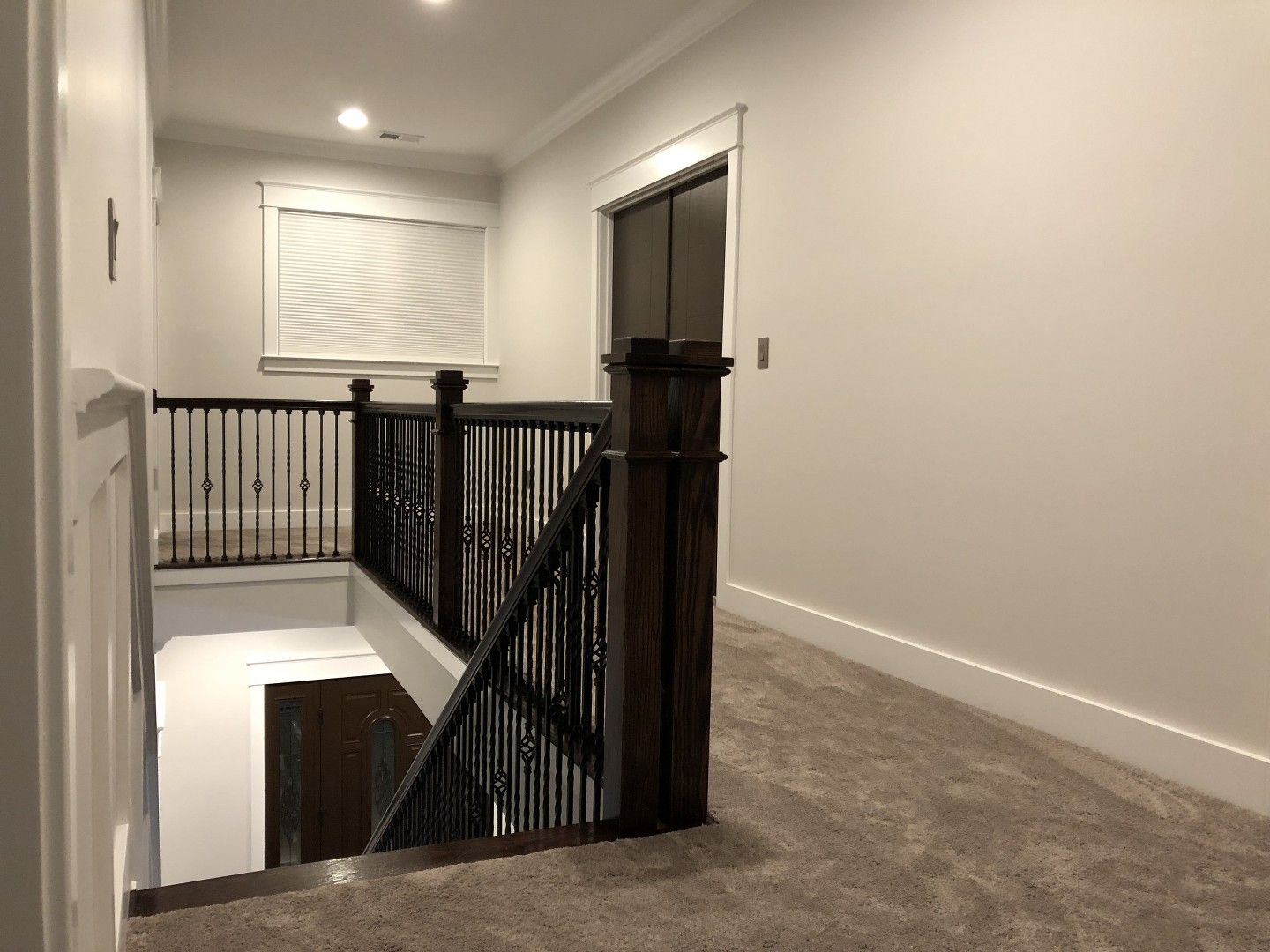 A hallway with stairs leading up to the second floor of a house.