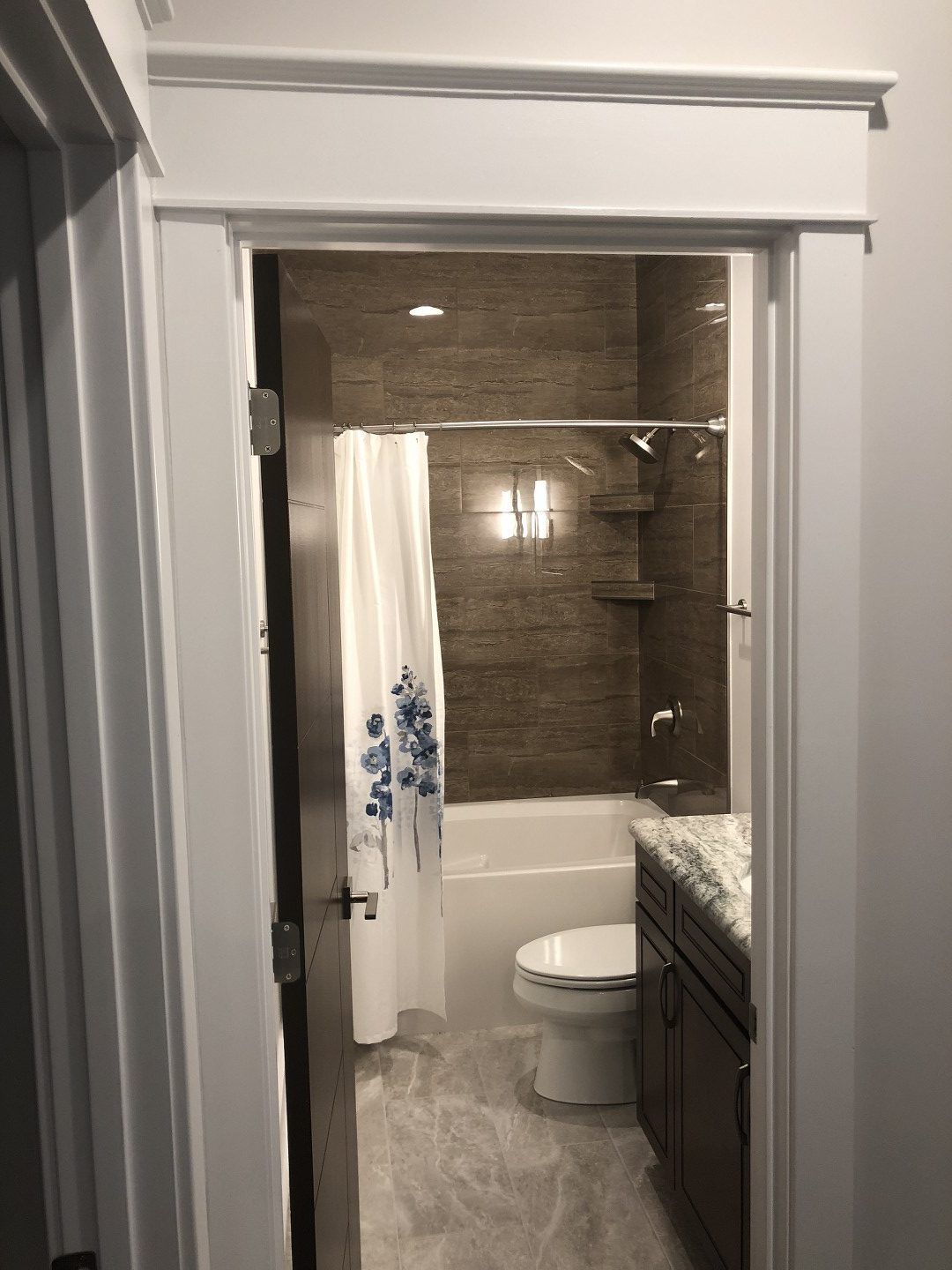 A bathroom with a toilet , bathtub and shower.
