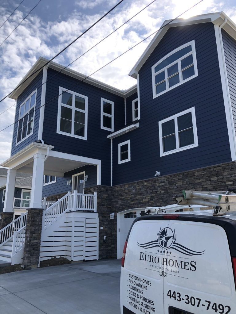 A blue house with a white van parked in front of it.