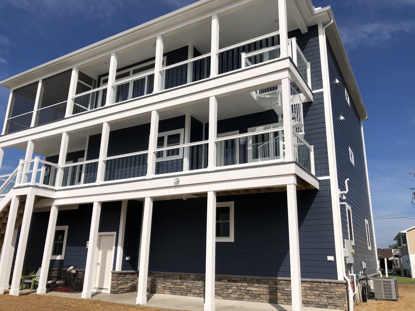 A large blue house with white columns and balconies.