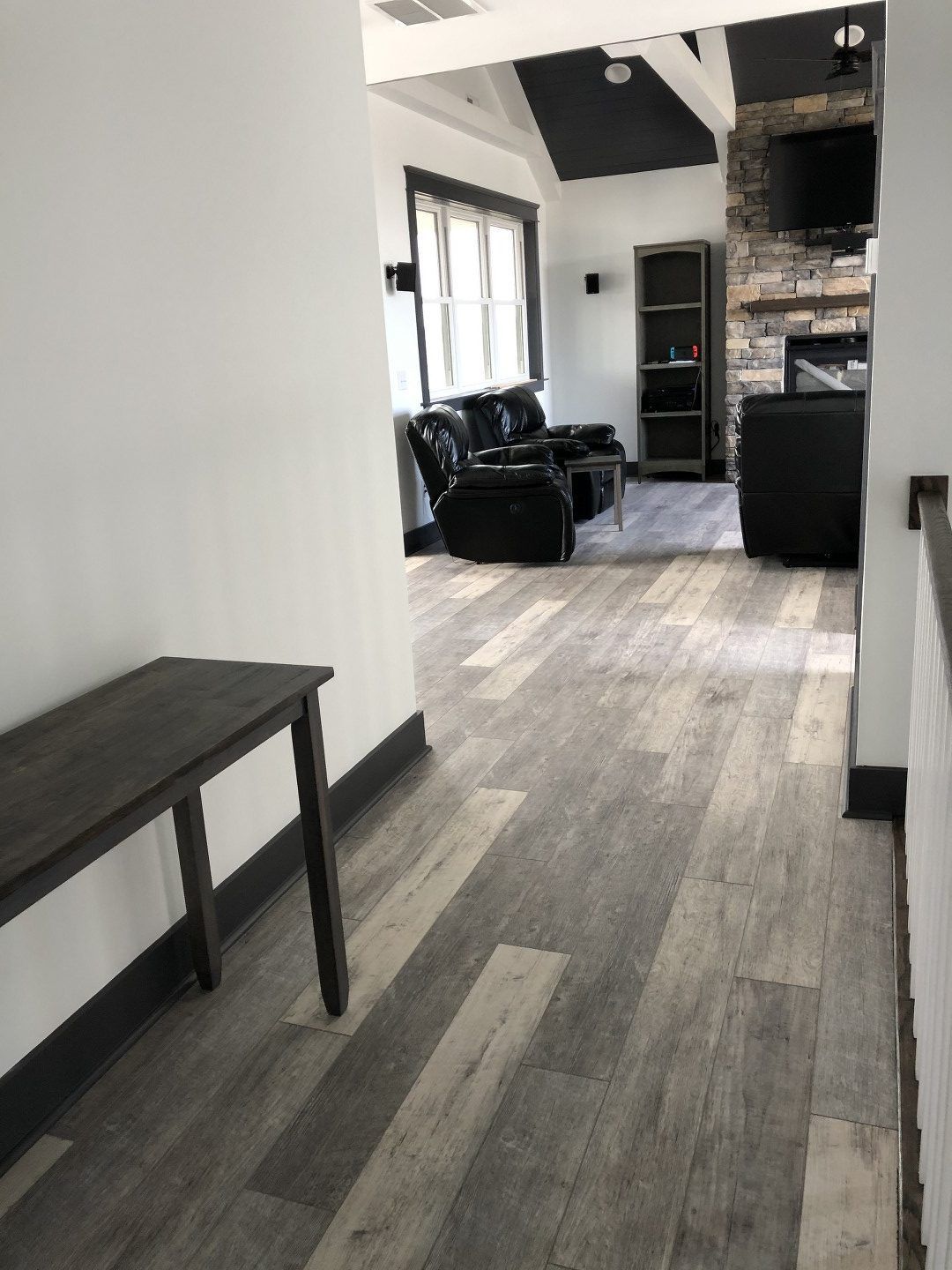 A hallway leading to a living room with a table and chairs.