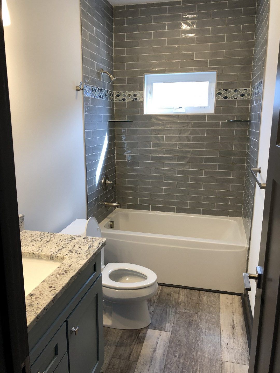 A bathroom with a toilet , sink , tub and shower.