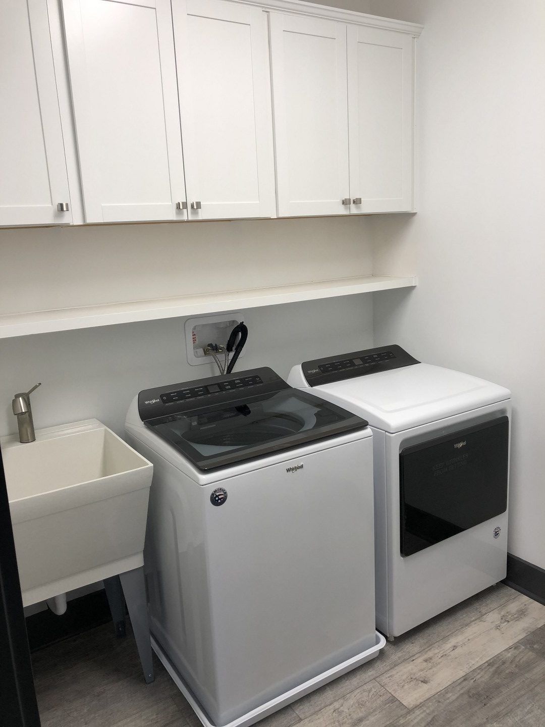 A laundry room with a washer and dryer and a sink.