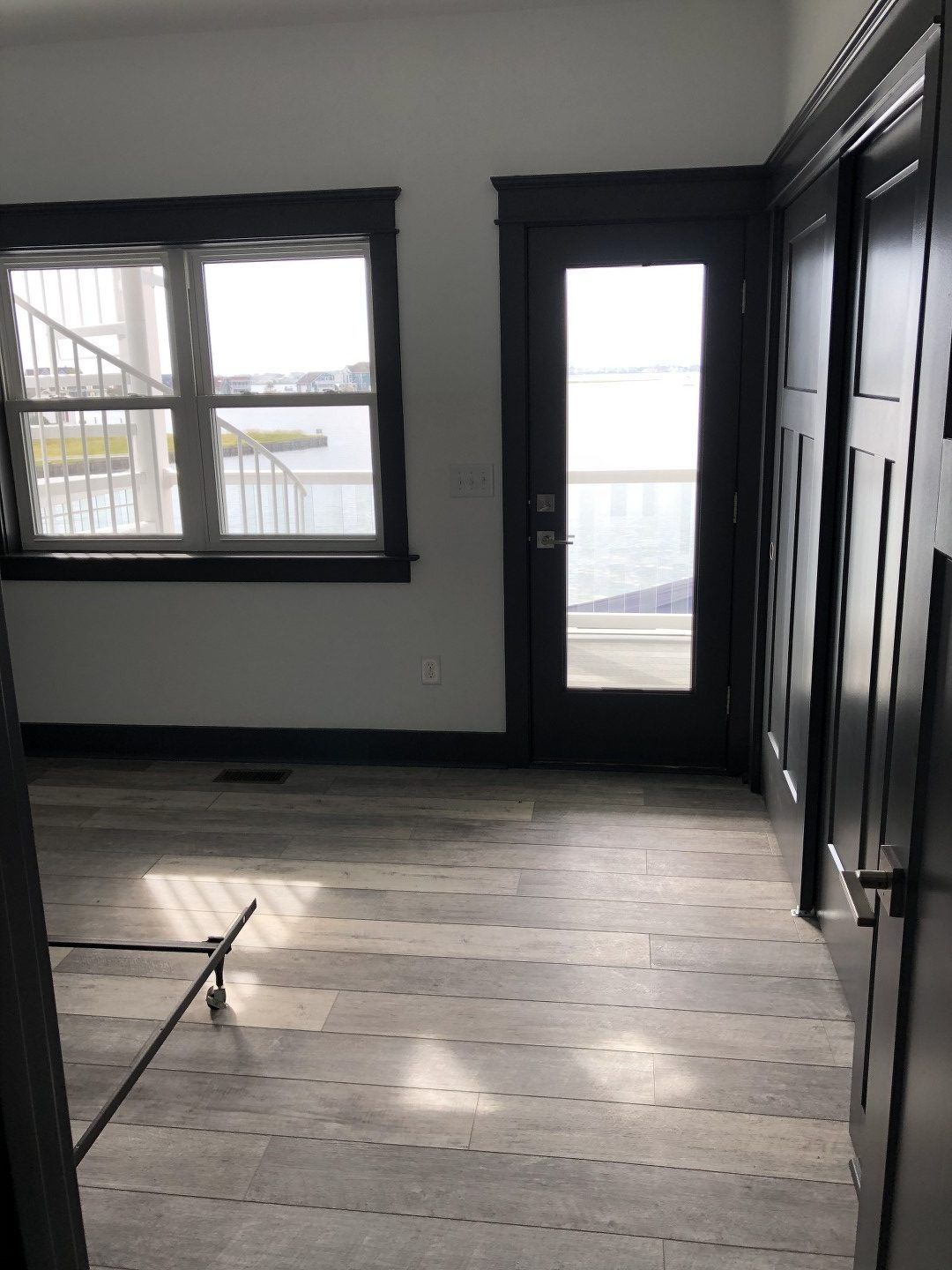 An empty room with two windows and a door