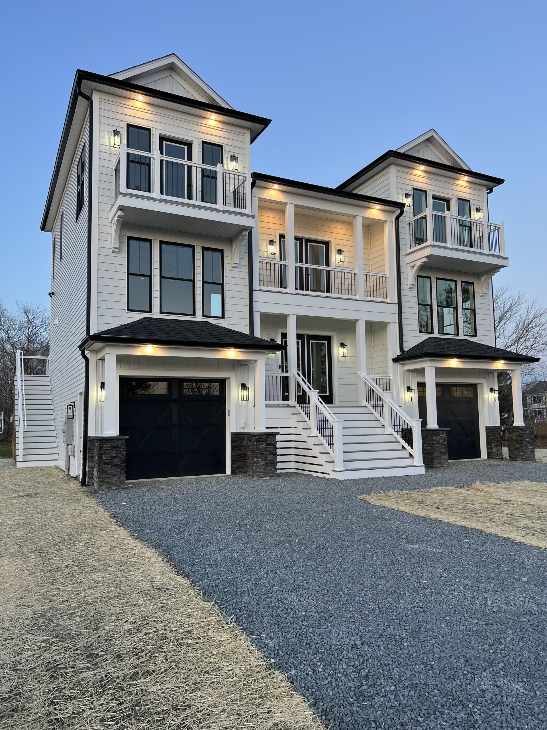A large white house with two garages and stairs