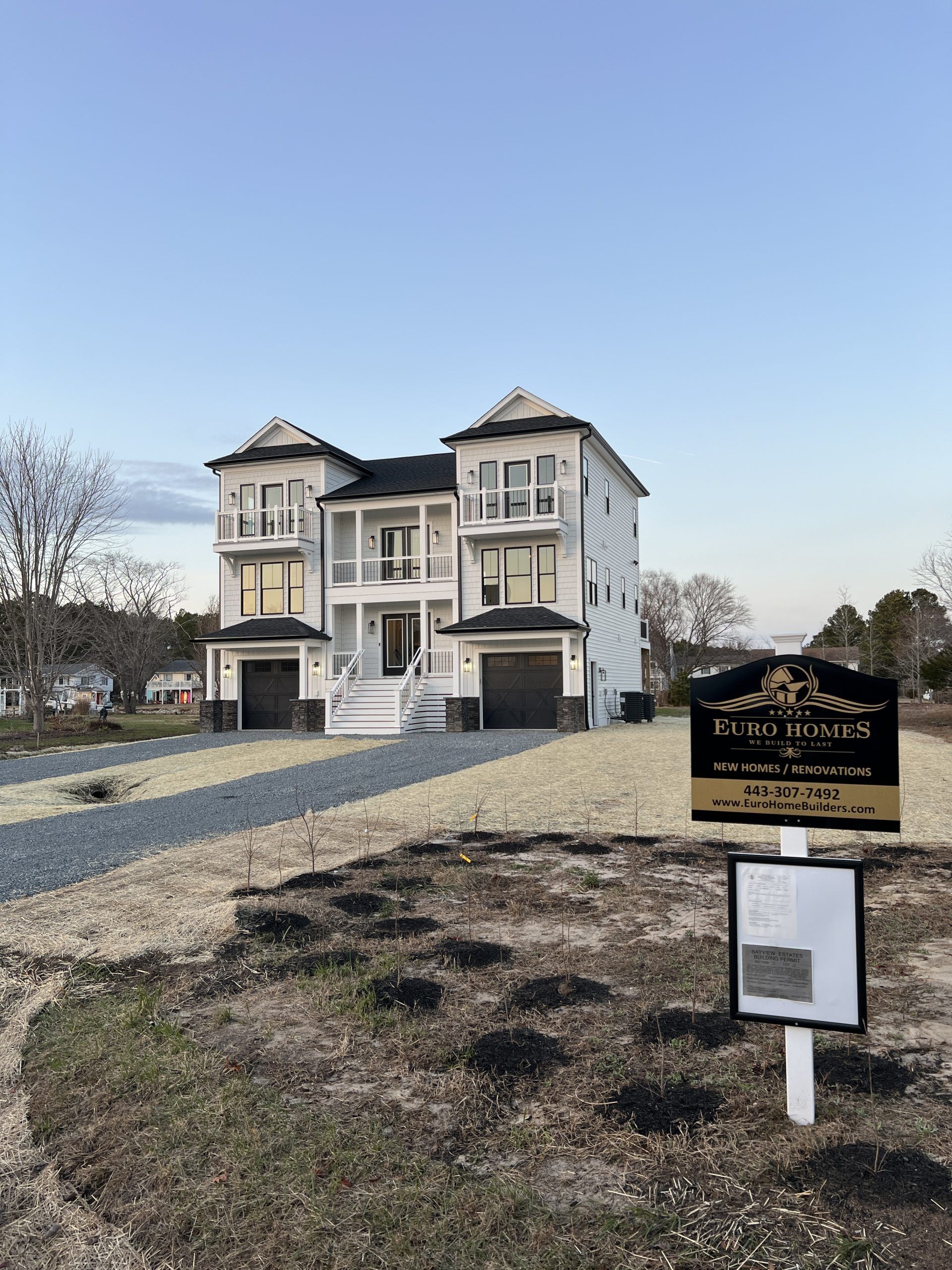 A large house with a for sale sign in front of it.