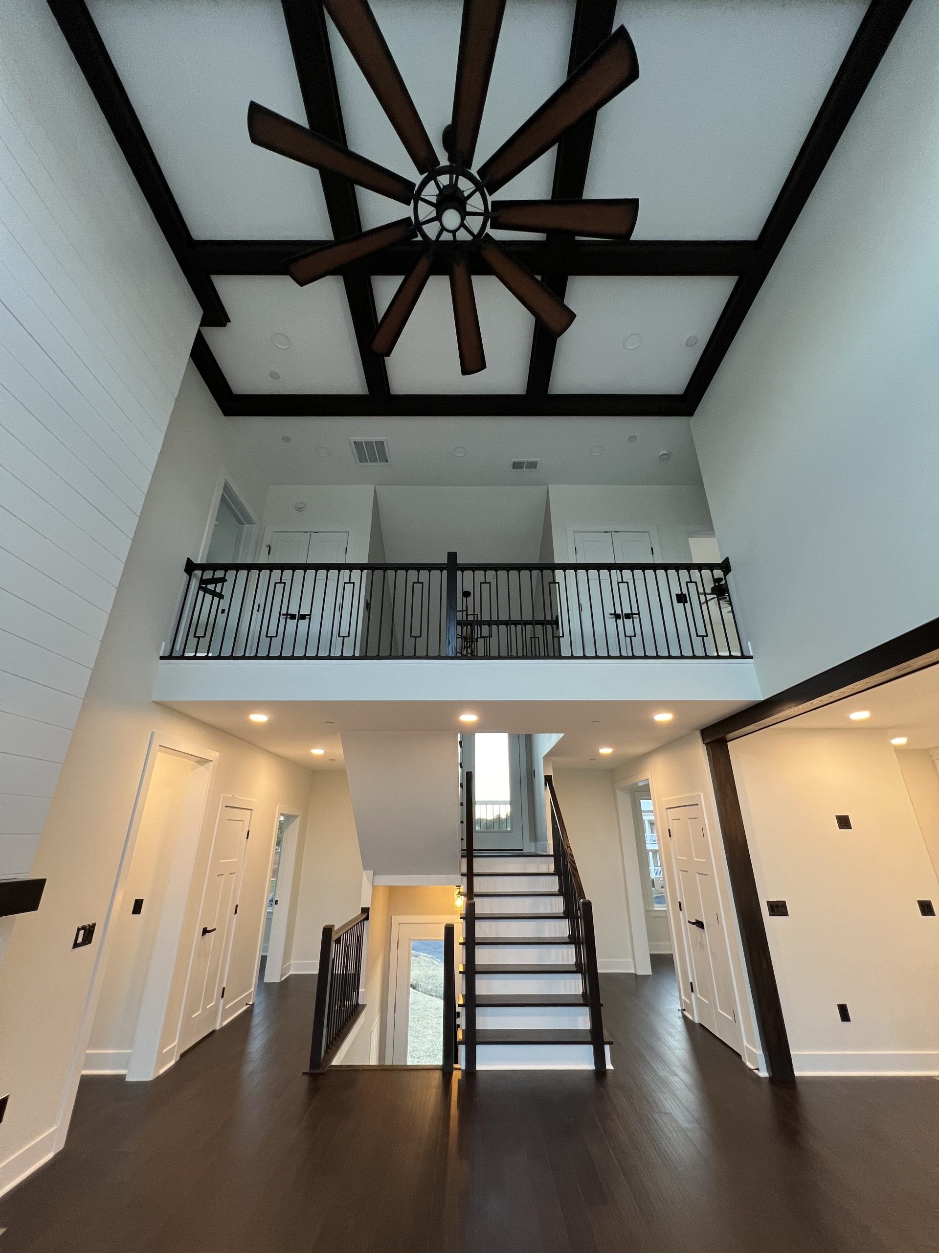 An empty house with a ceiling fan and stairs