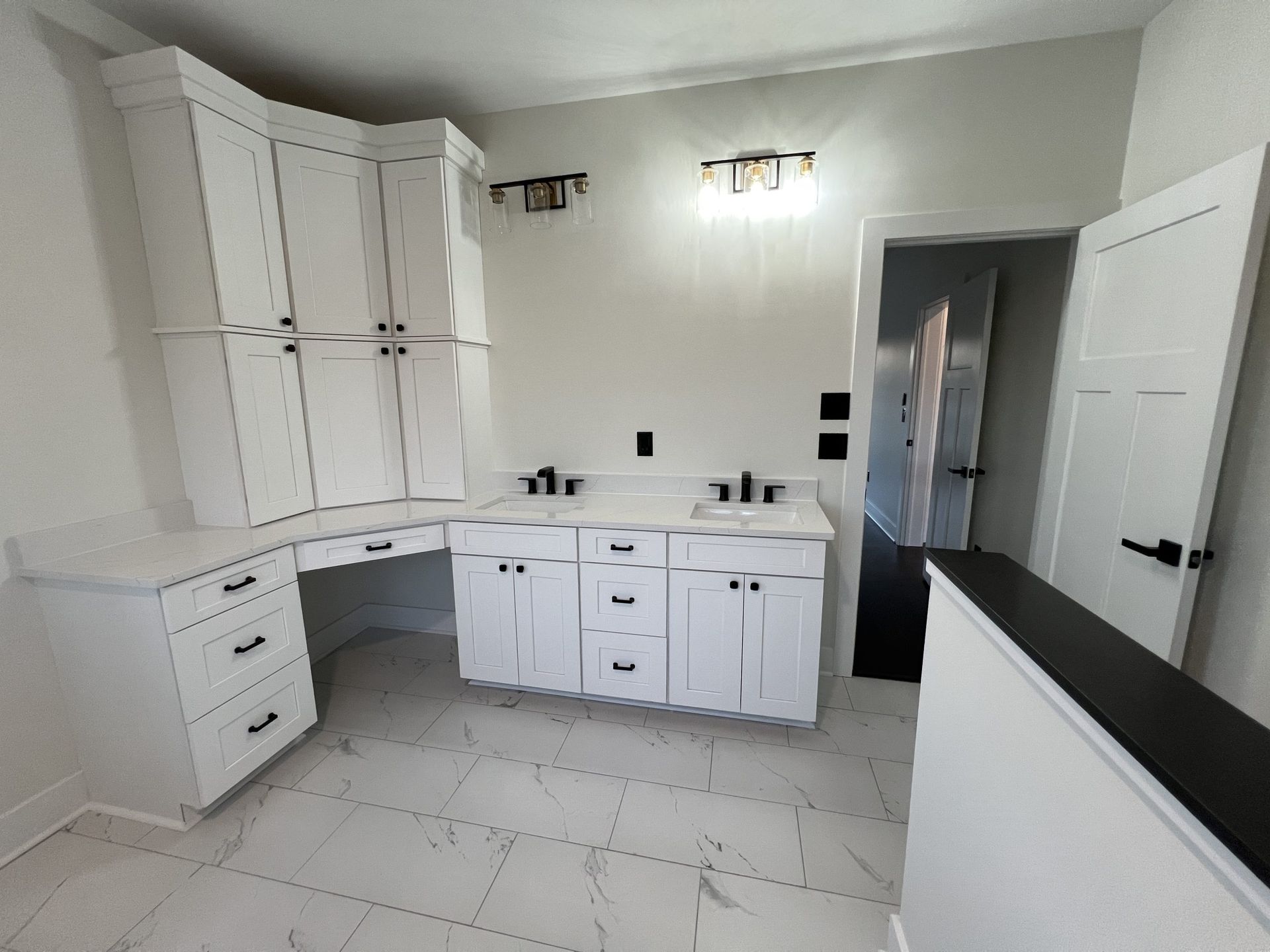 A bathroom with white cabinets and a sink