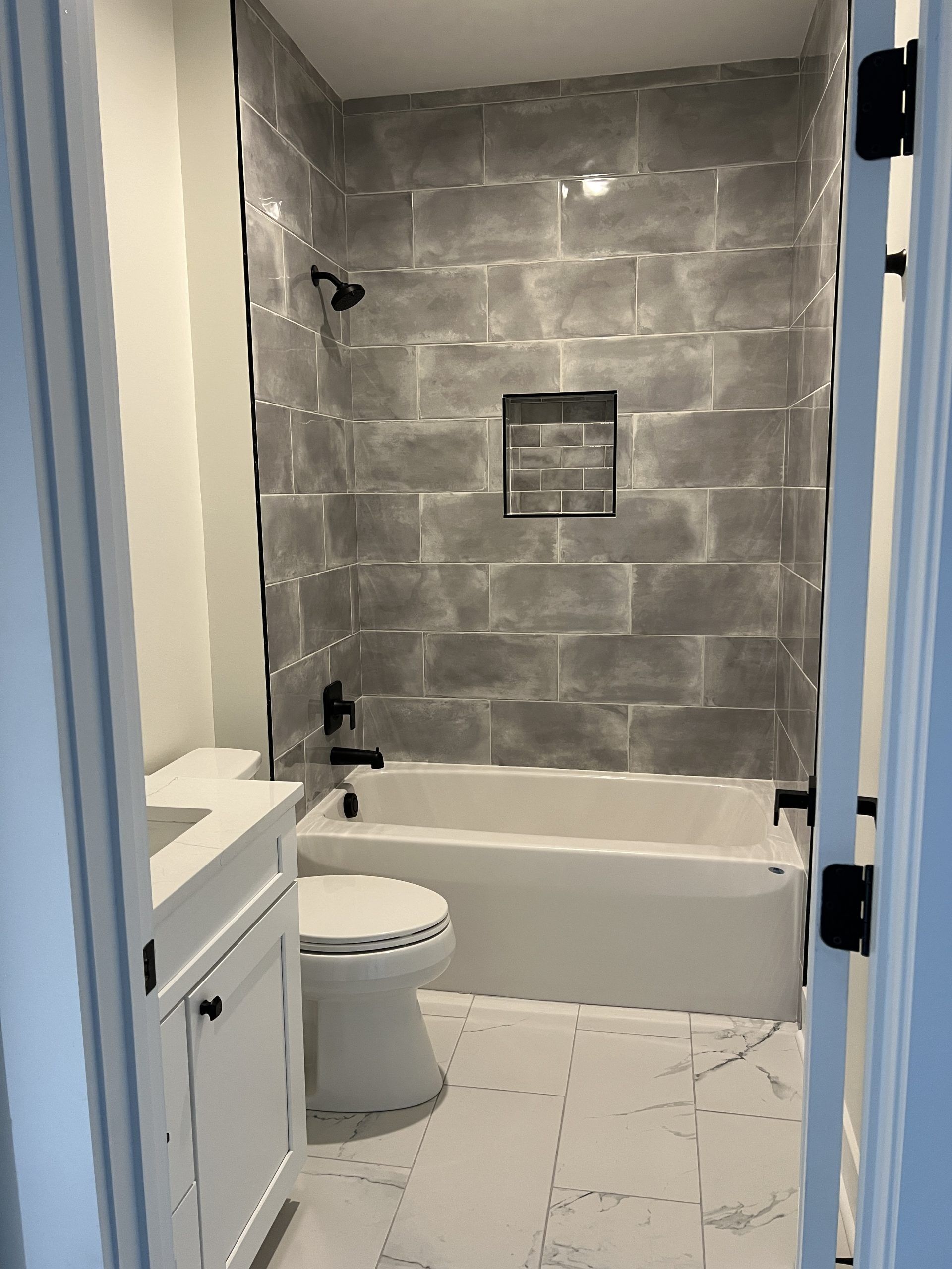 A bathroom with a toilet , bathtub , sink and shower.