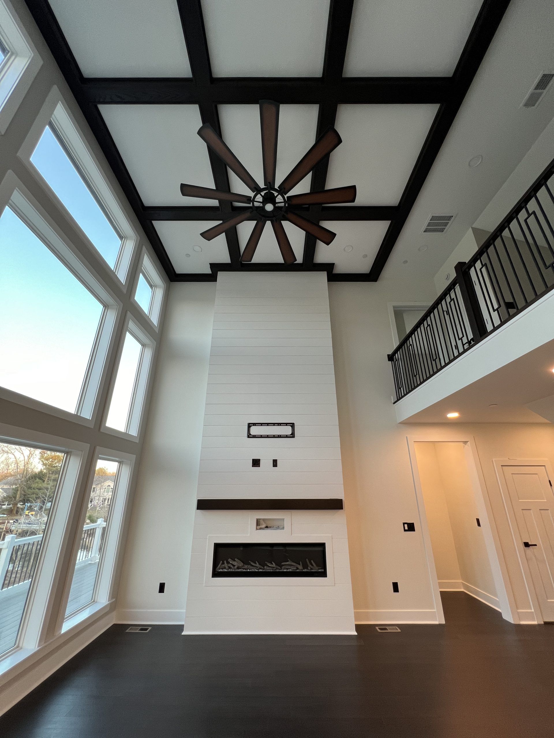 A living room with a fireplace and a ceiling fan
