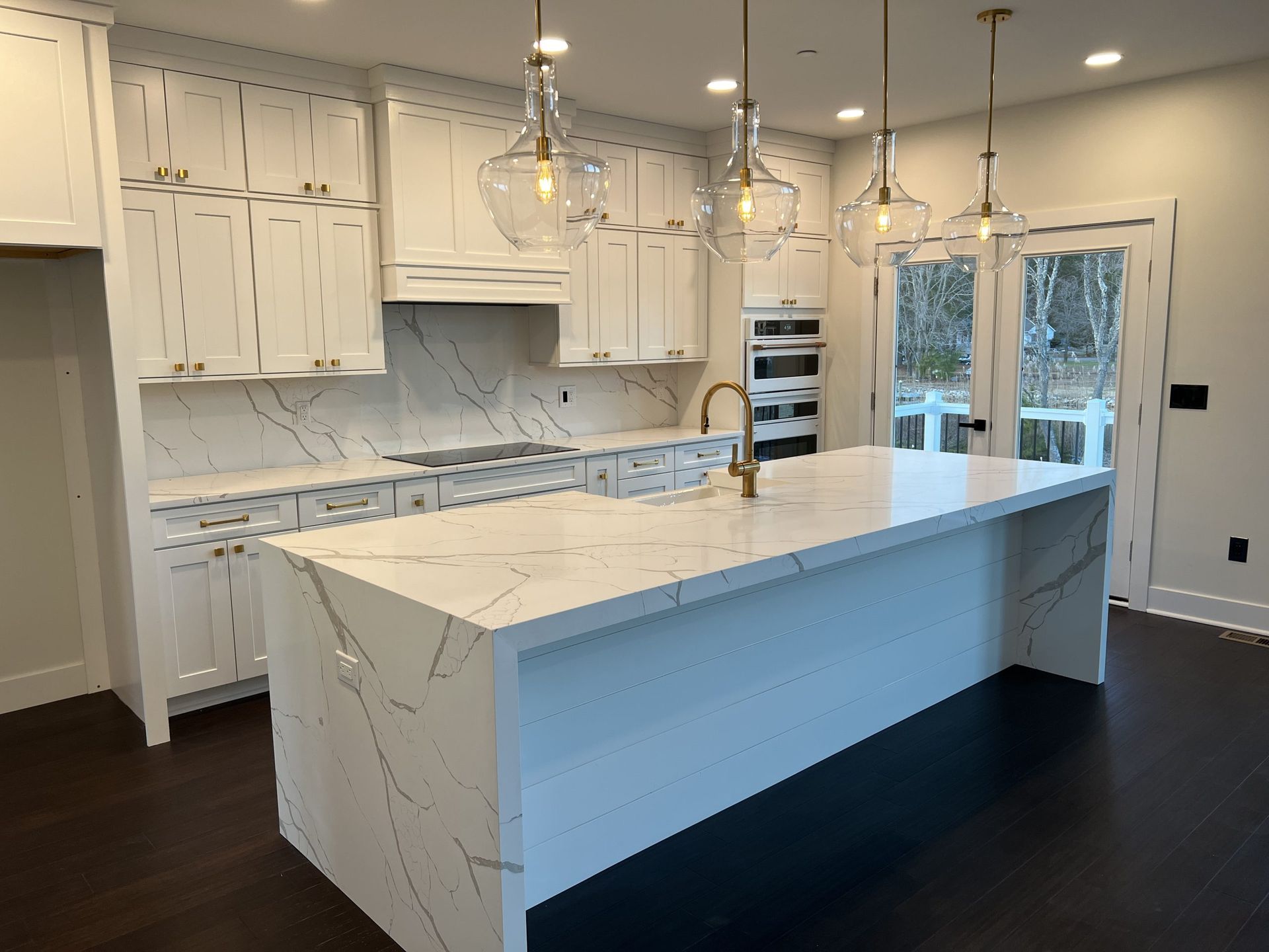 A kitchen with white cabinets and a large island in the middle.