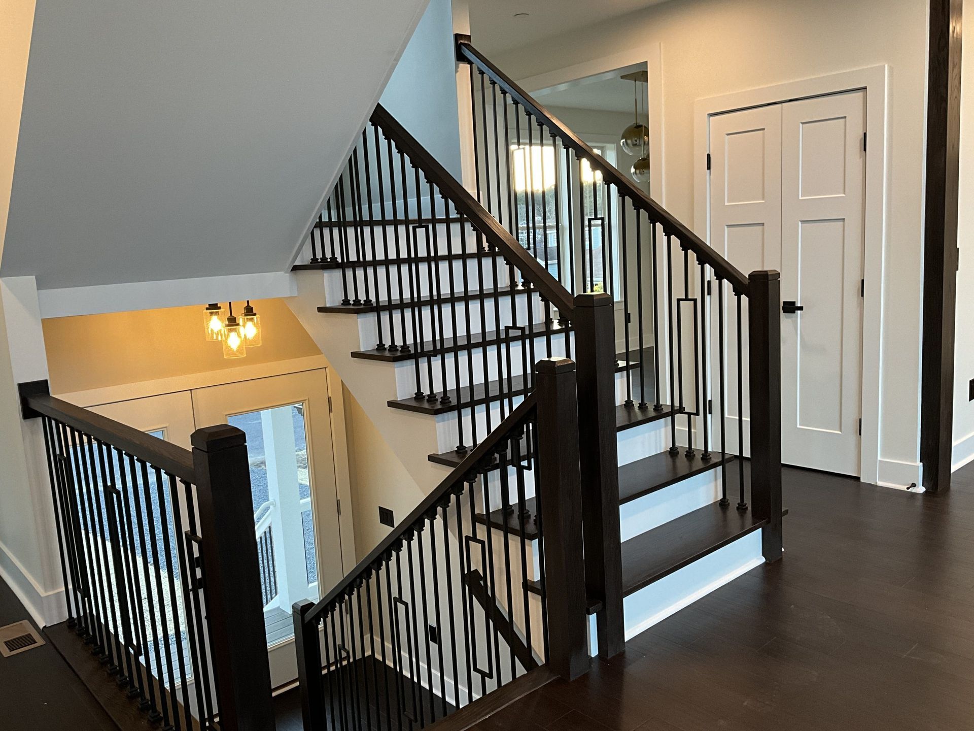 A staircase in a house with a black railing and wooden steps.
