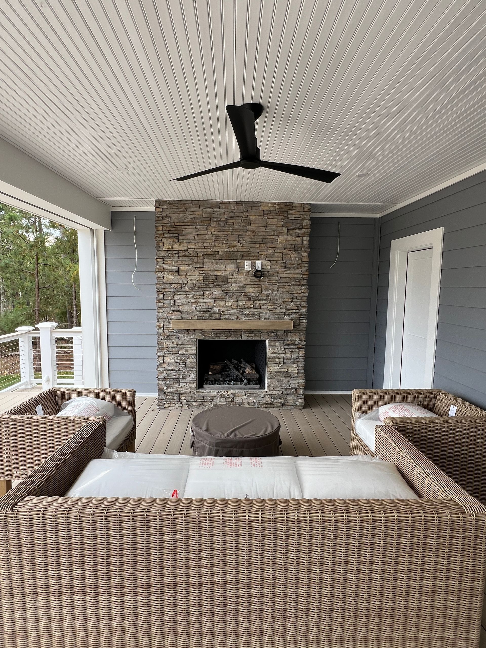 A living room with a fireplace and a ceiling fan.