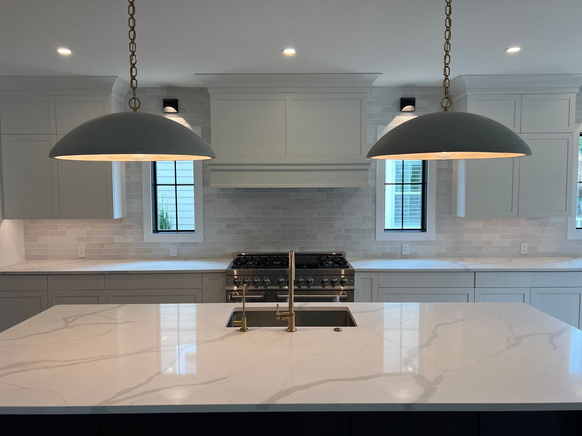 A kitchen with white cabinets and a stove and sink.