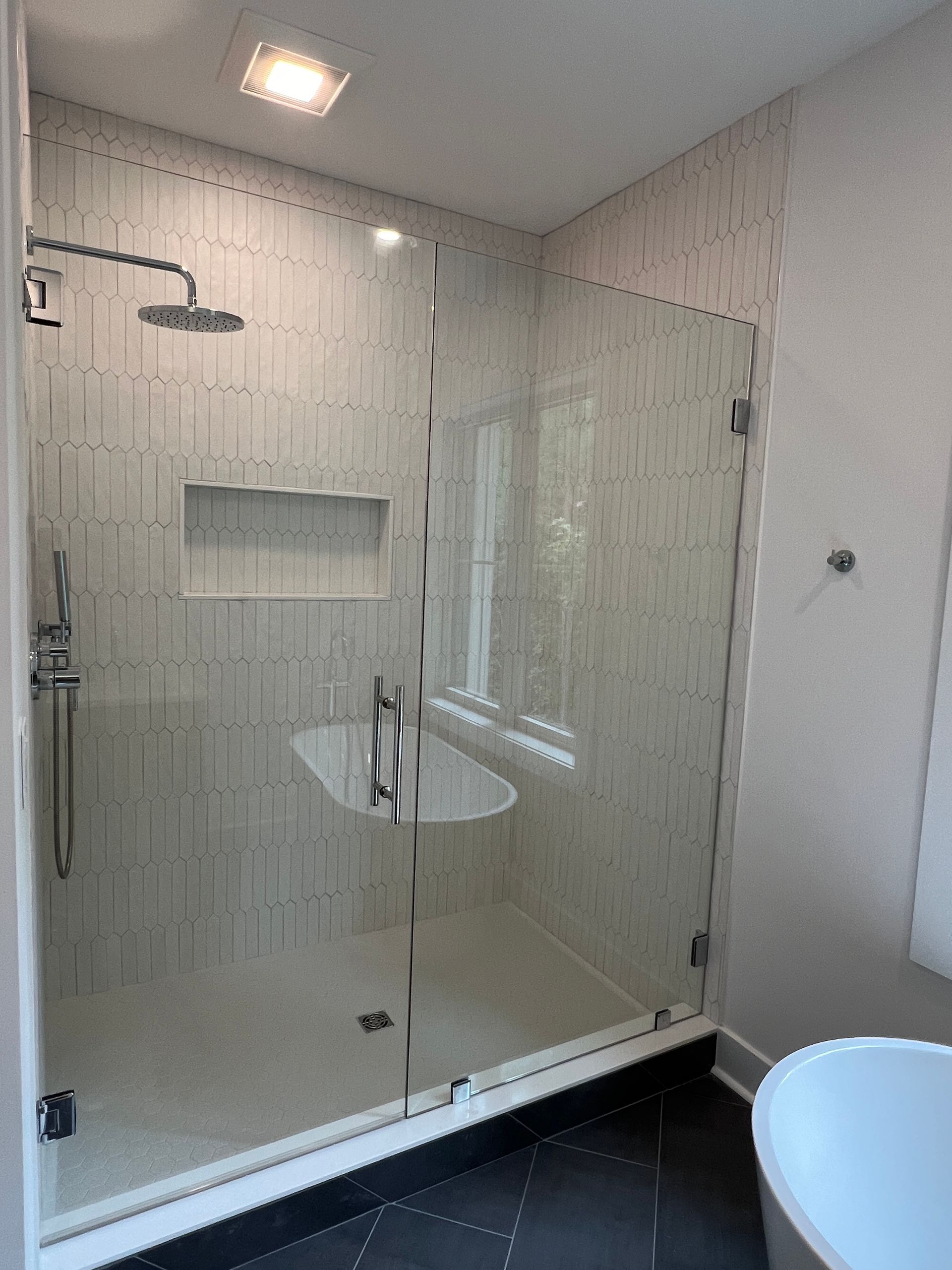 A bathroom with a walk in shower and a bathtub.