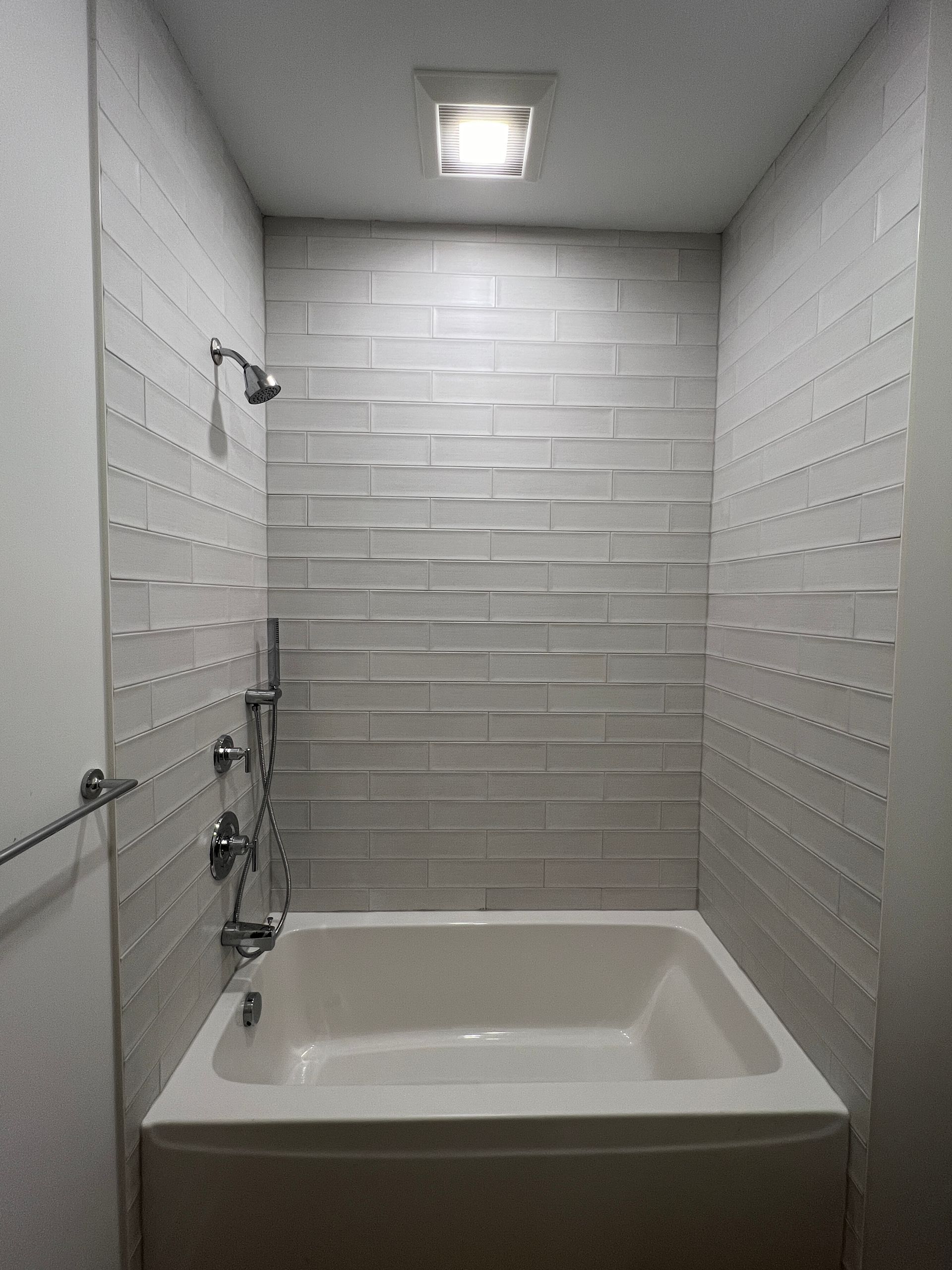 A bathroom with a bathtub and a shower.