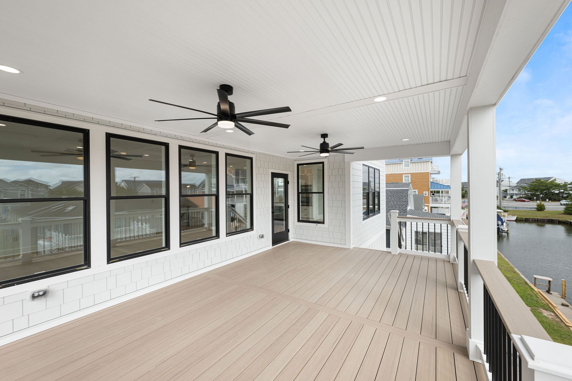 A large porch with a lot of windows and a ceiling fan.