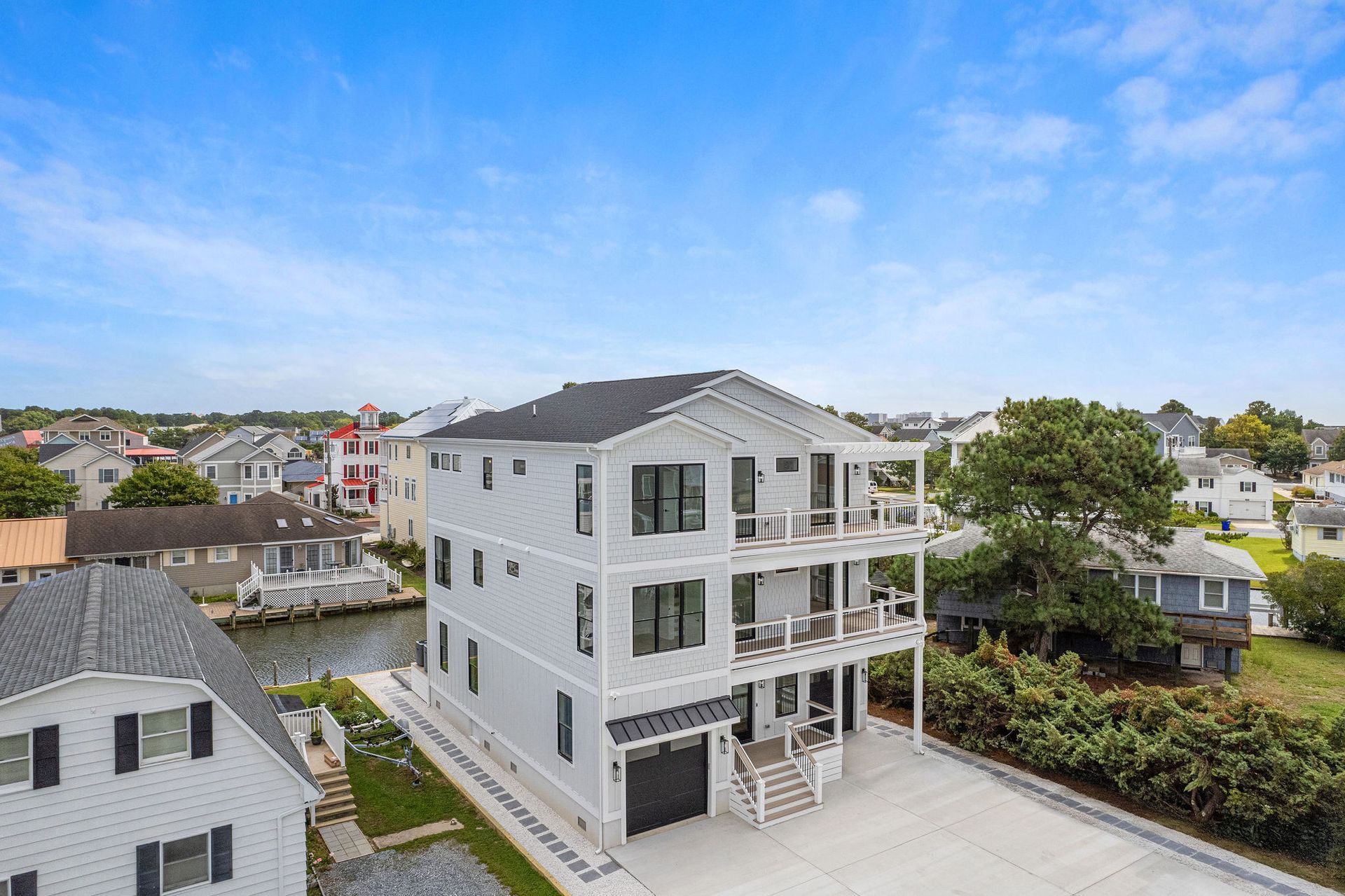 An aerial view of a large white house in a residential area.
