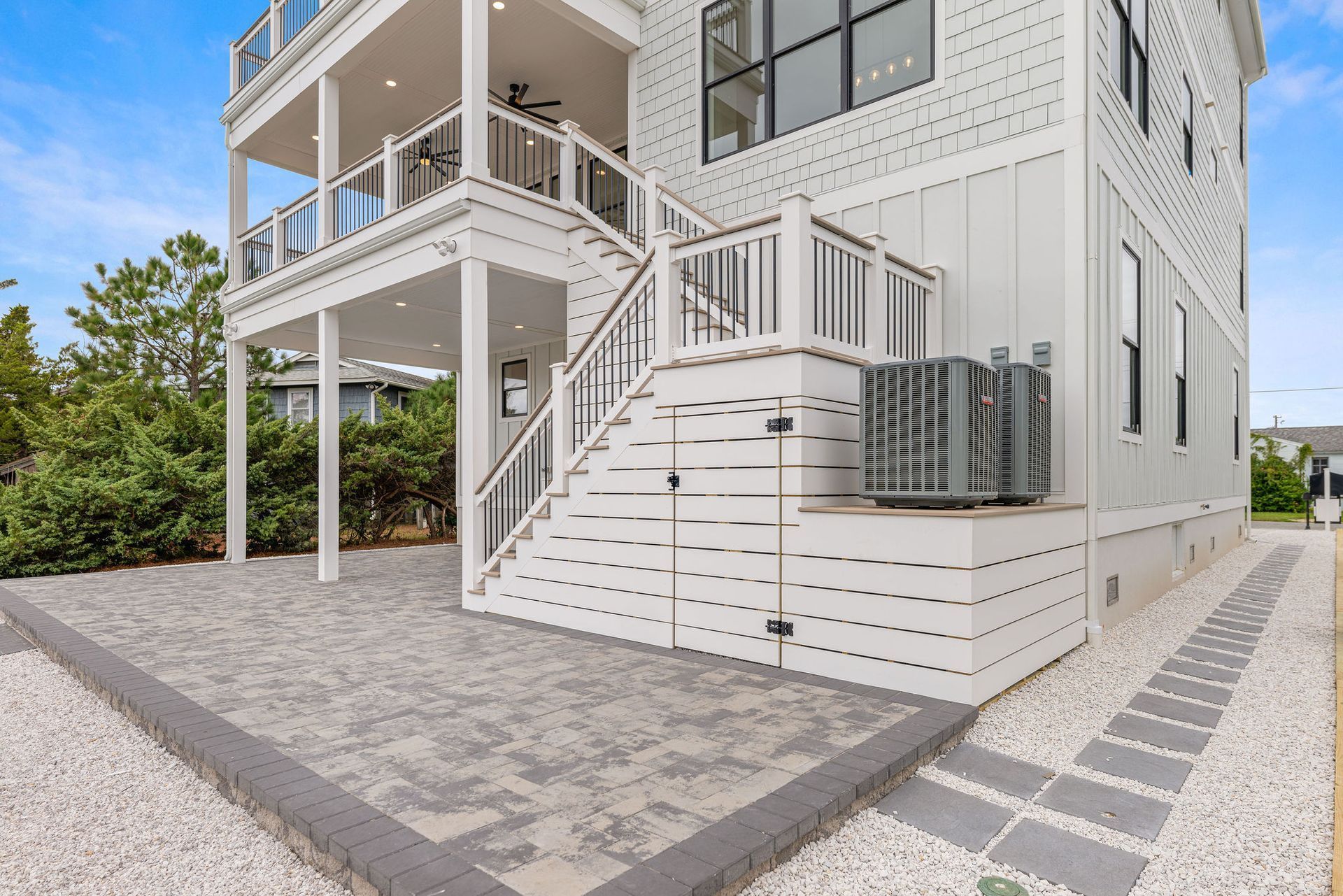 A large white house with stairs leading up to the second floor.