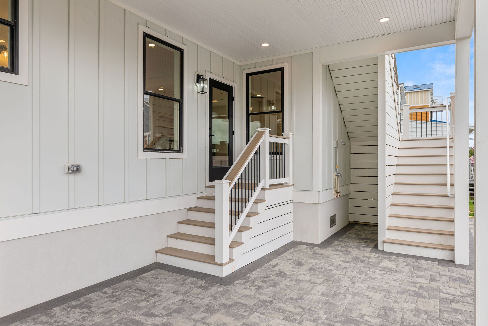 A white house with stairs leading up to the second floor.