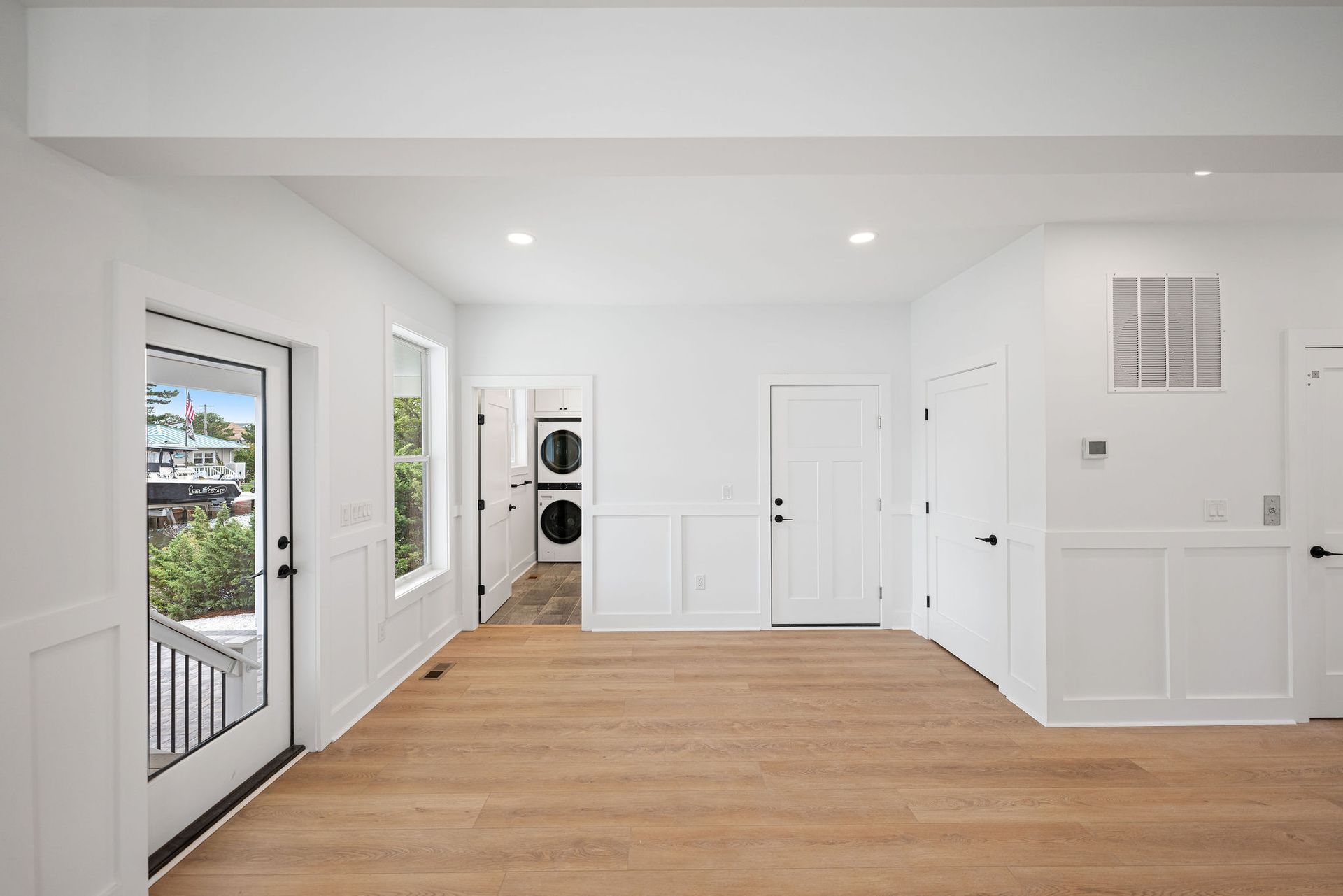 A large empty room with hardwood floors and white walls.