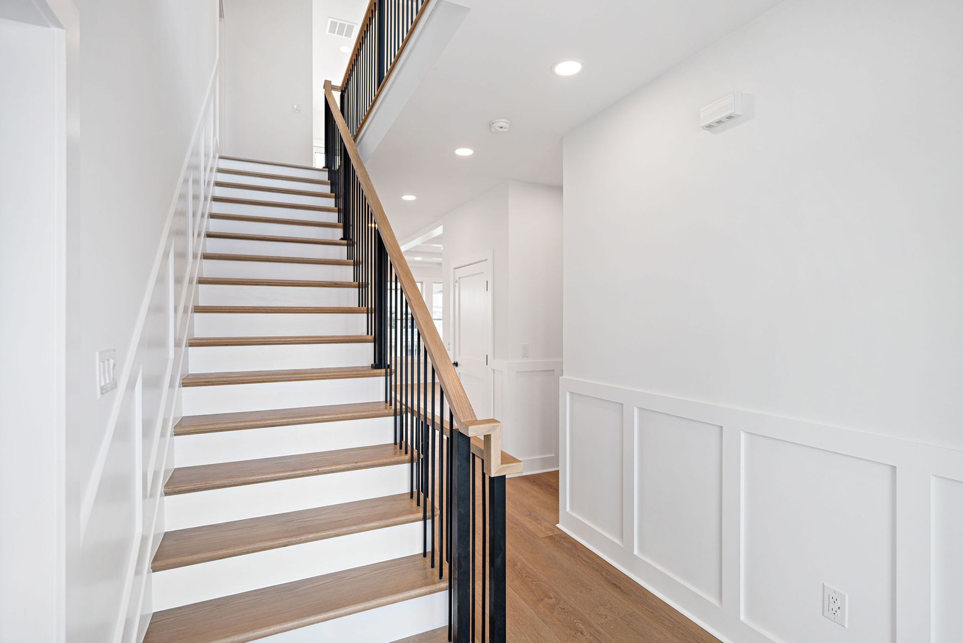 A hallway with stairs leading up to the second floor of a house.