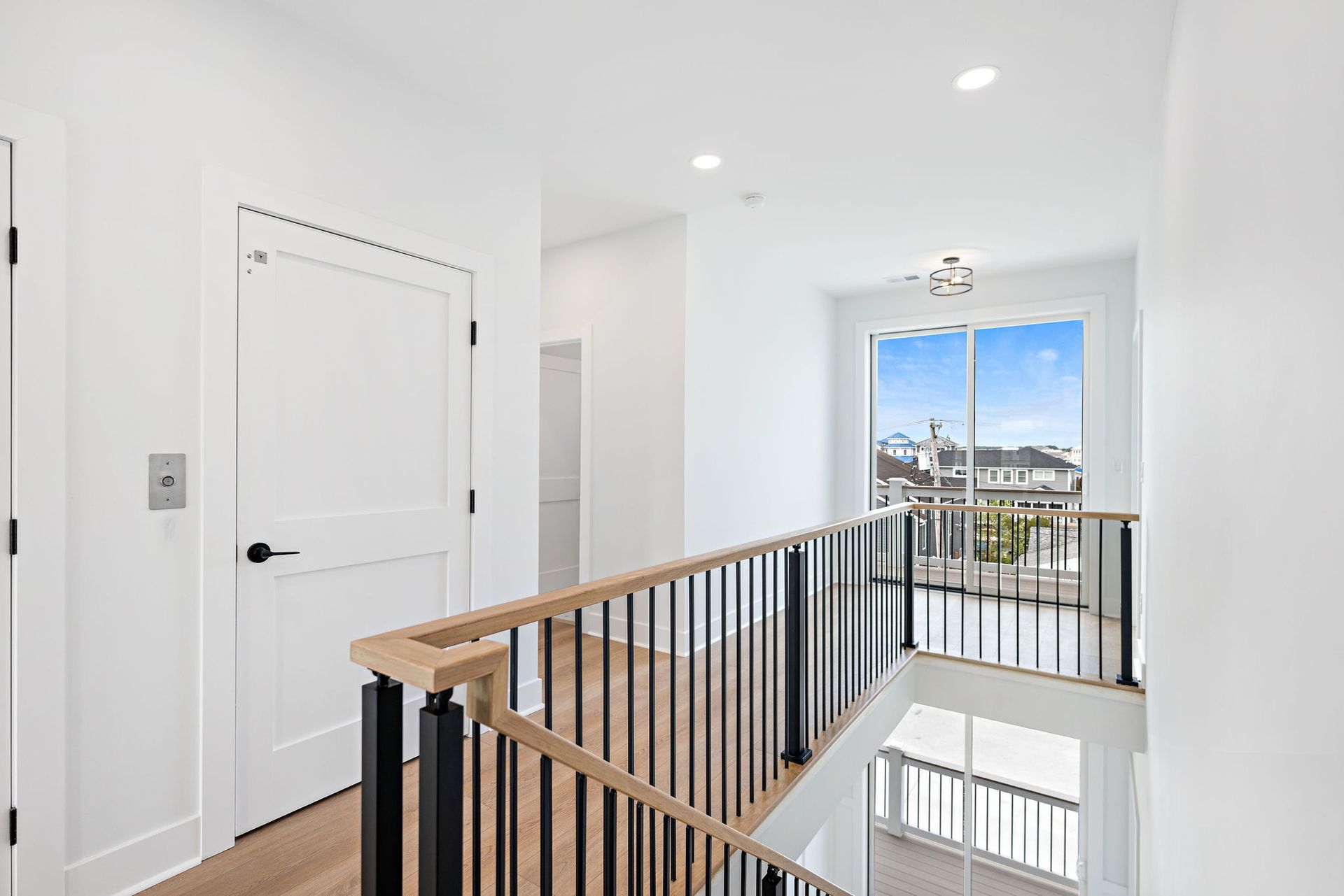 A staircase with a wooden railing and a sliding glass door in a house.