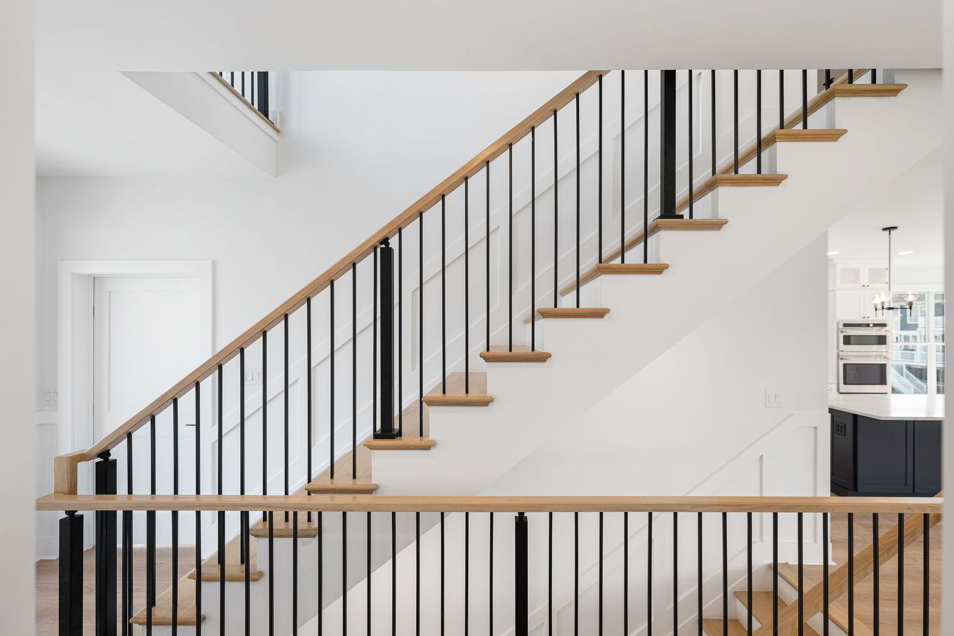 The stairs are made of wood and metal and have a black railing.
